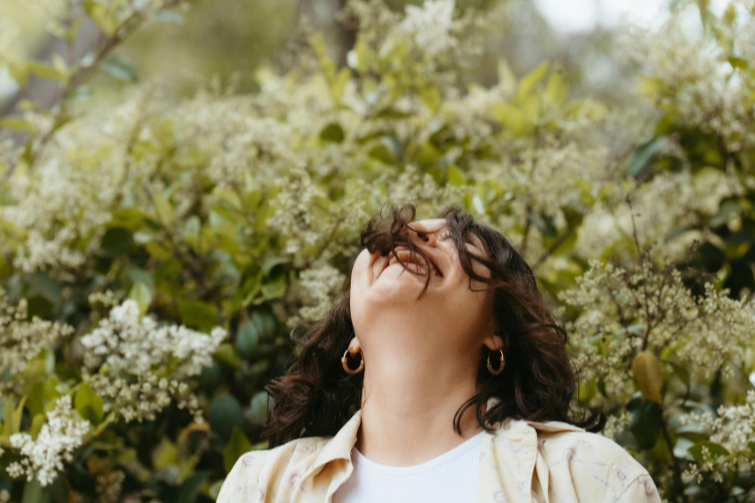 woman laughing in blooming garden