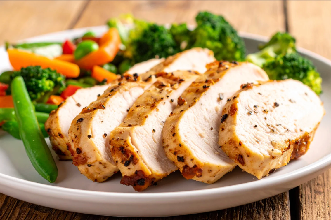 sliced roast chicken and vegetables on white plate