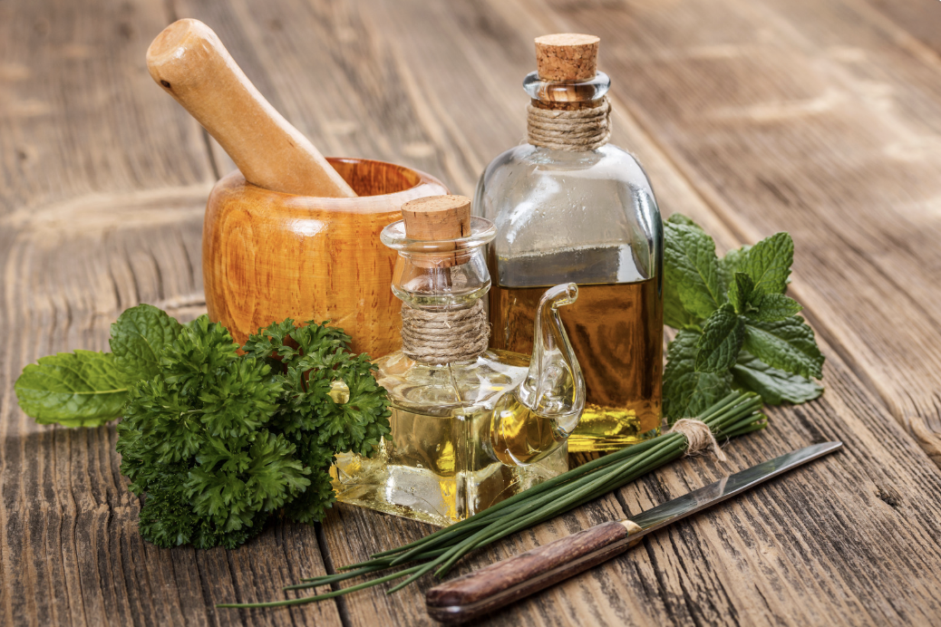grouping of oils and herbs on wooden table