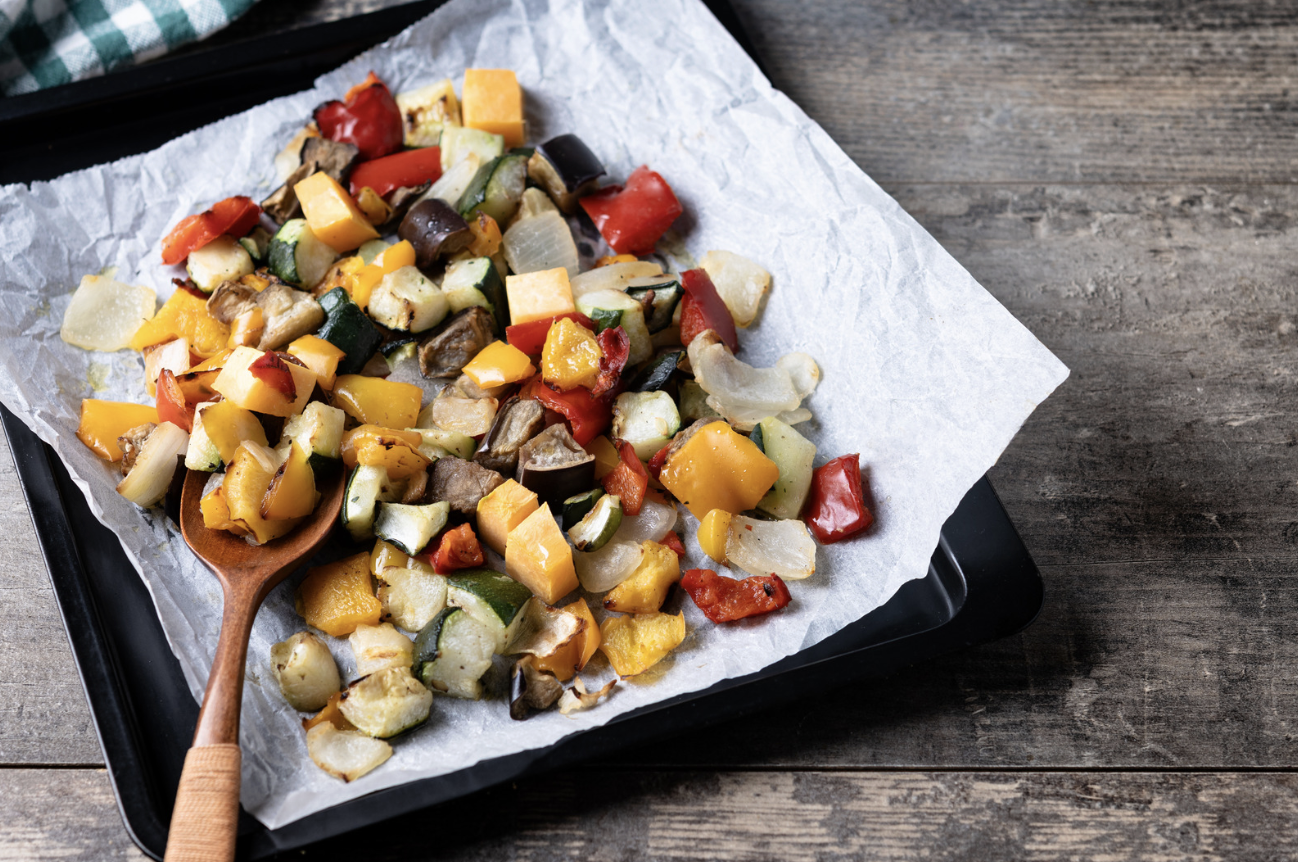 roasted vegetables on parchment with wooden spoon