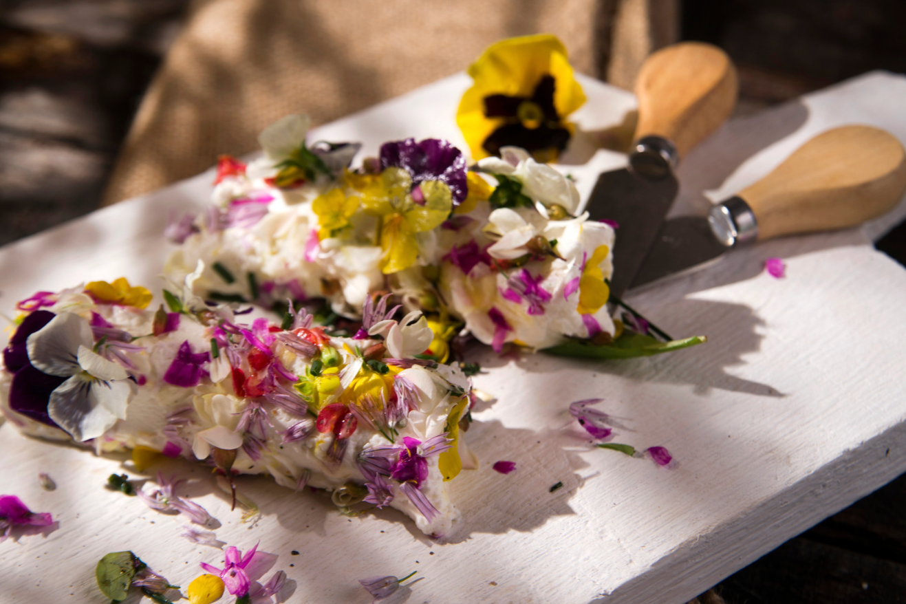 close up of goat butter with edible flowers