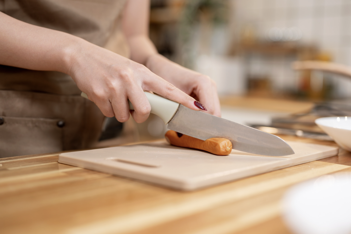 close up of woman using knife to slice carrots