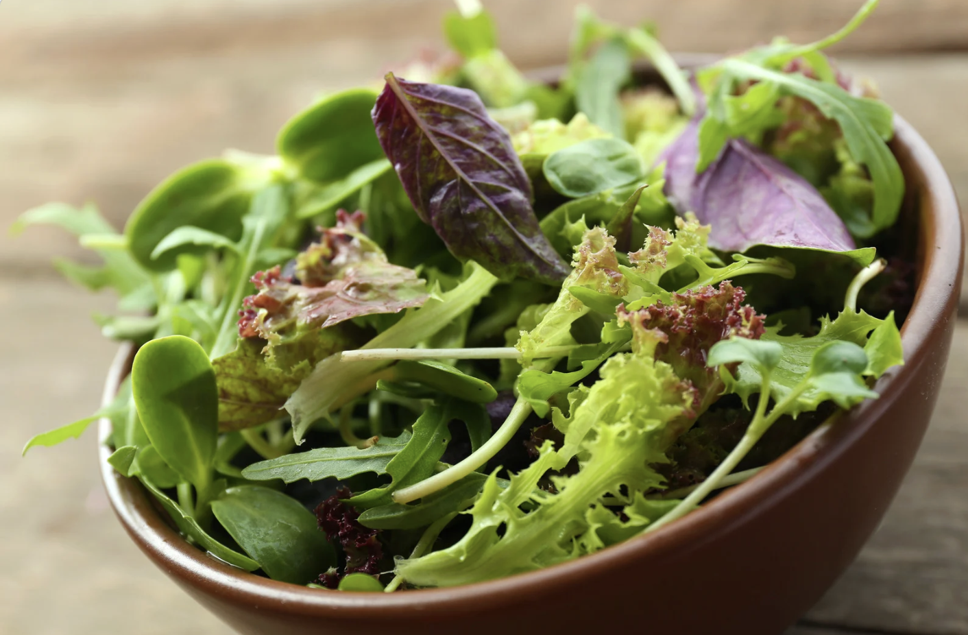 wooden bowl filled with bitter greens
