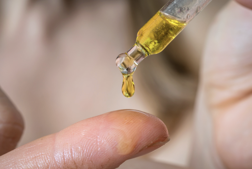 dropper of skin oil dripping onto finger