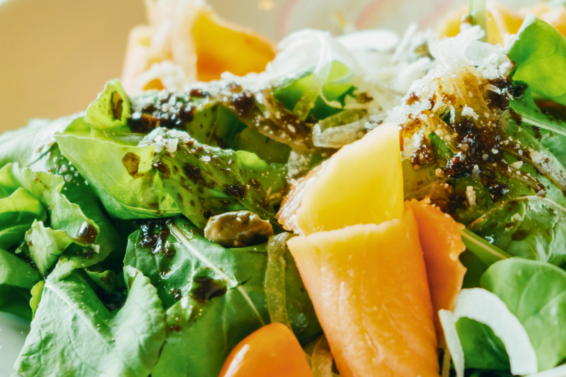 bowl of leafy greens with citrus and olive oil