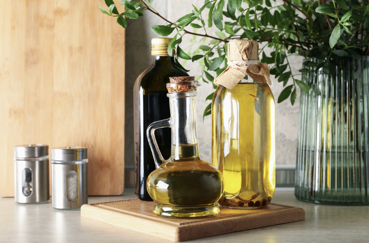 various plant oils in glass bottles on kitchen counter