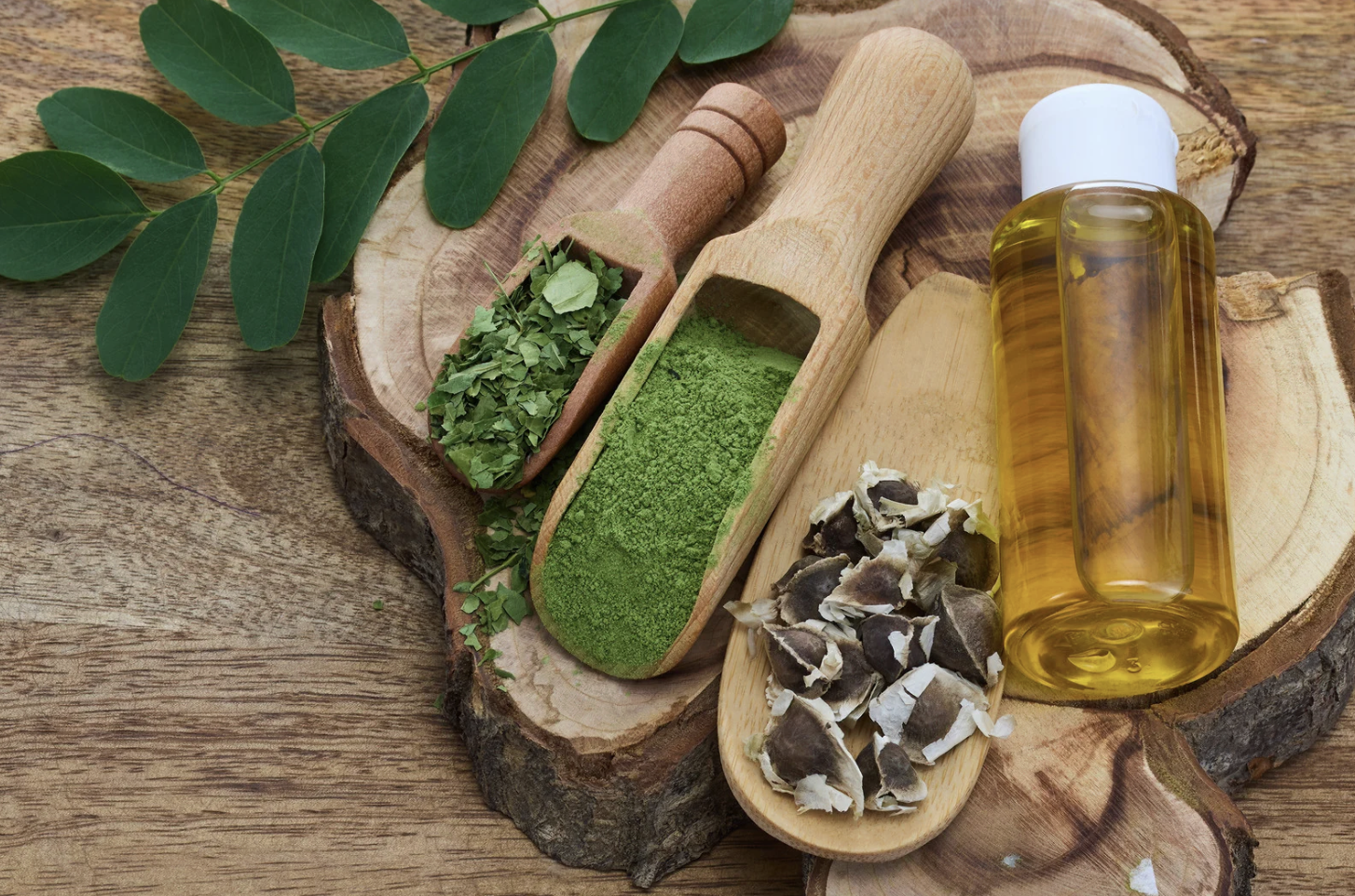 wooden spoons with botanicals and jar of oil