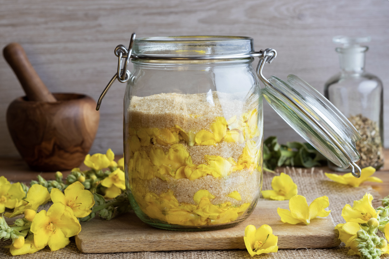 yellow flowers in jar of sugar
