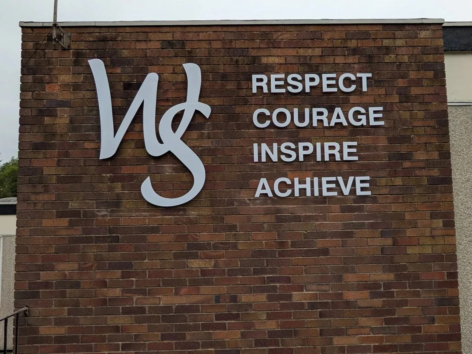  White gloss acrylic letters installed using PVC Locator Fixings to the exterior brick wall at Windlehurst School 