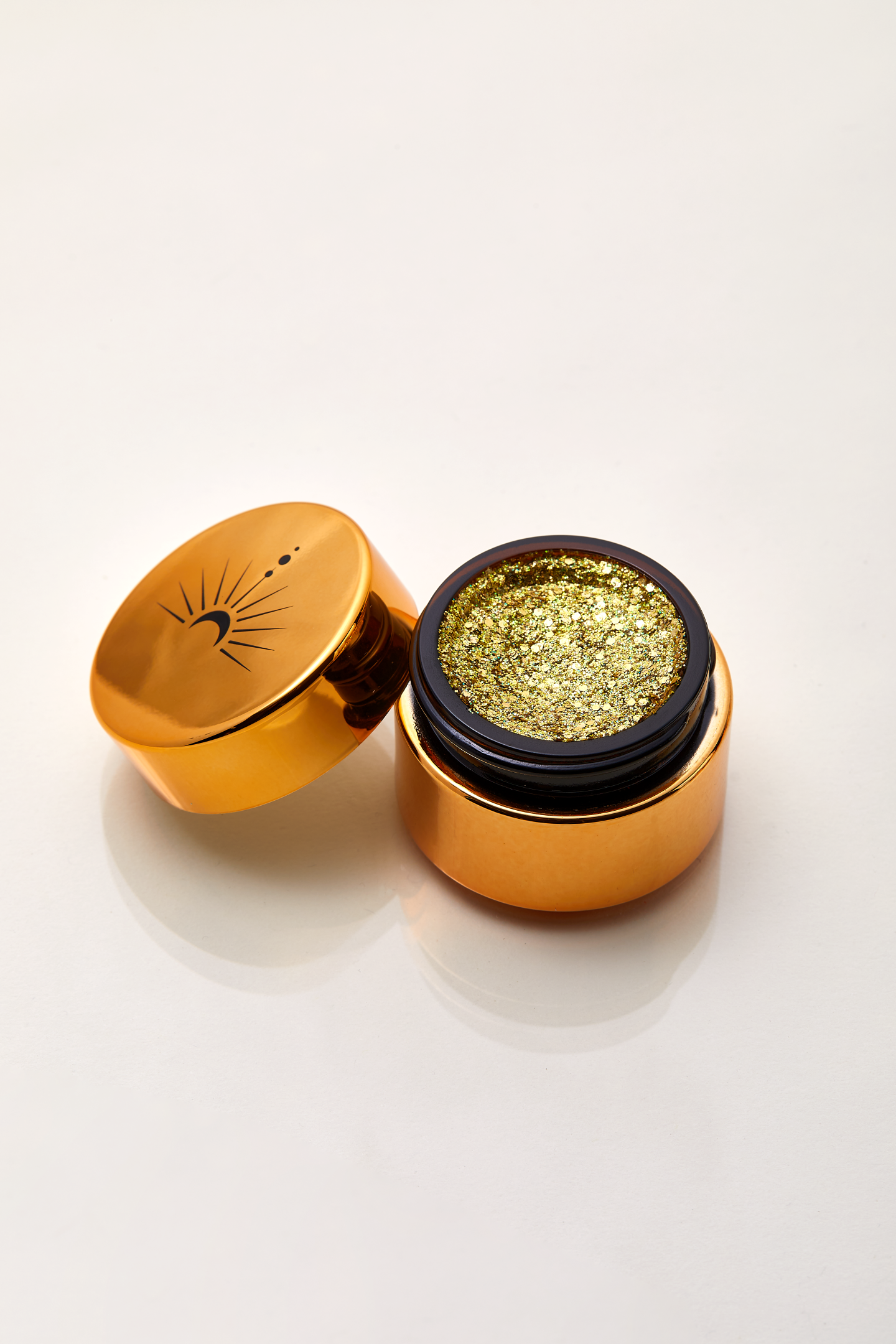 Shimmering Solid gold with iridescent sparkle of plant based glitter cream in a vegan non toxic formula dries to a water resistant powder finish