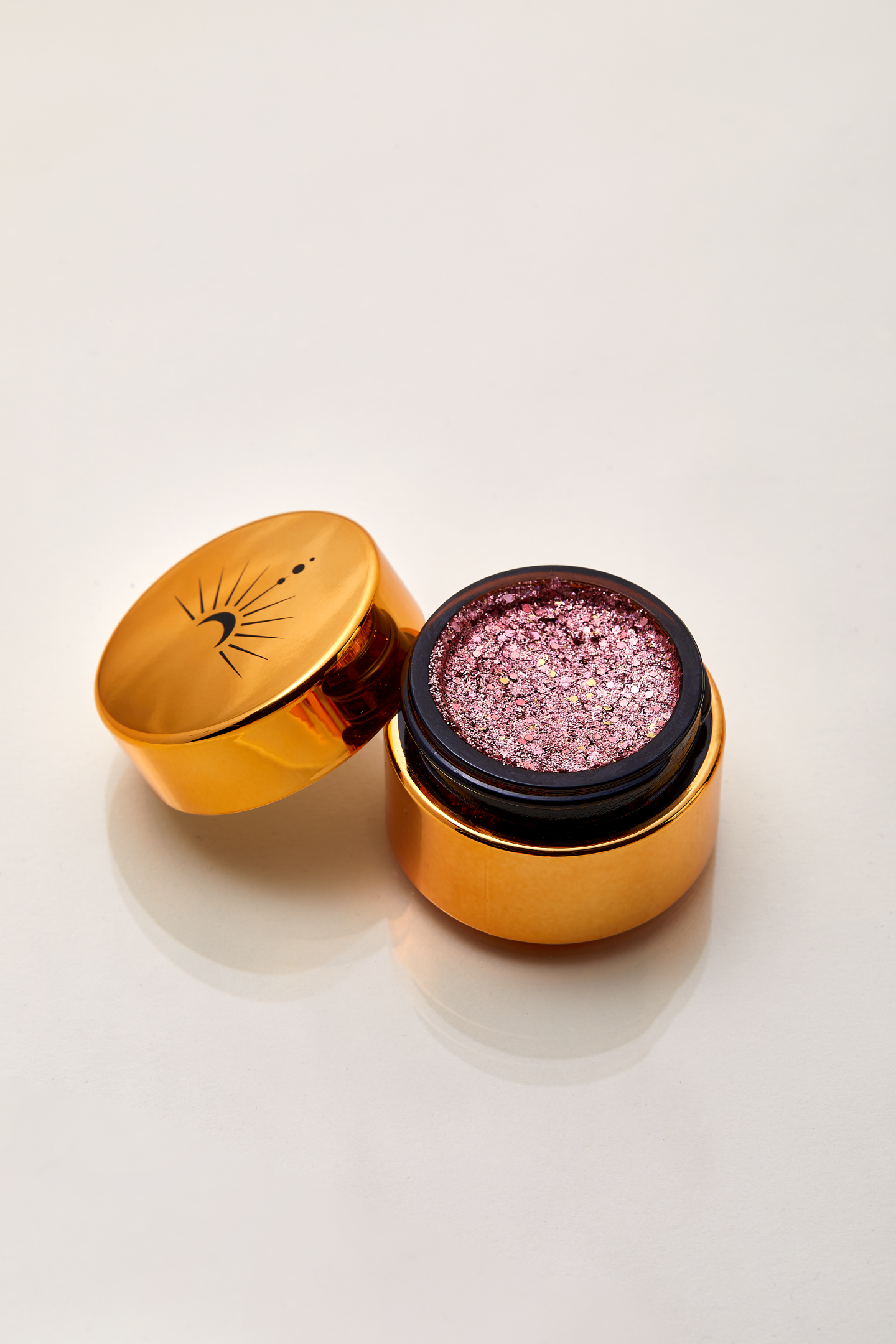 Shimmery rose gold sparkling plant based glitter cream in a vegan non toxic formula dries to a water resistant powder finish