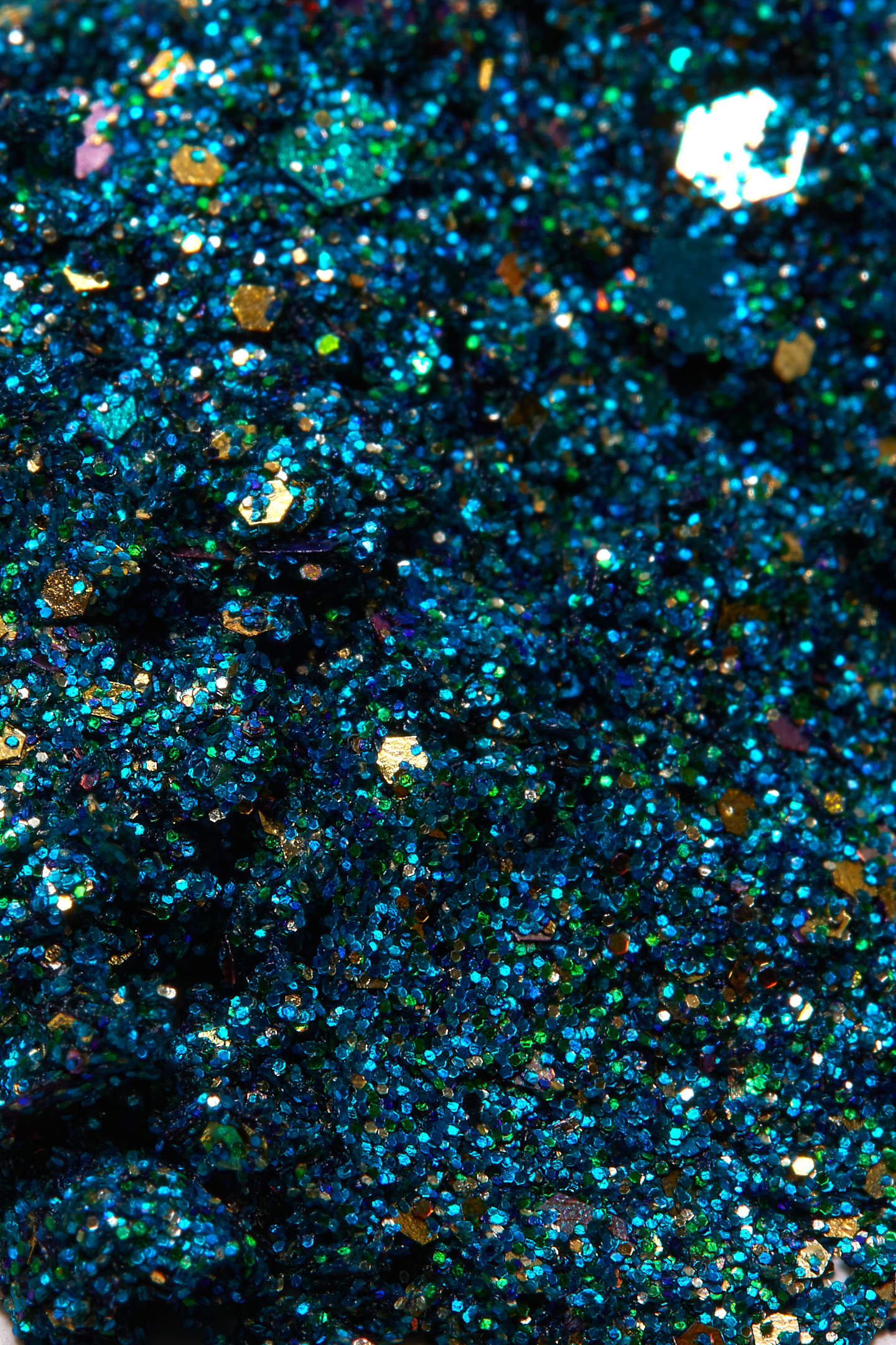 Sparkling array of blue teal turquoise green with flecks of gold and silver for a shimmering dramatic plant based glitter cream in a vegan non toxic formula dries to a water resistant  powder finish