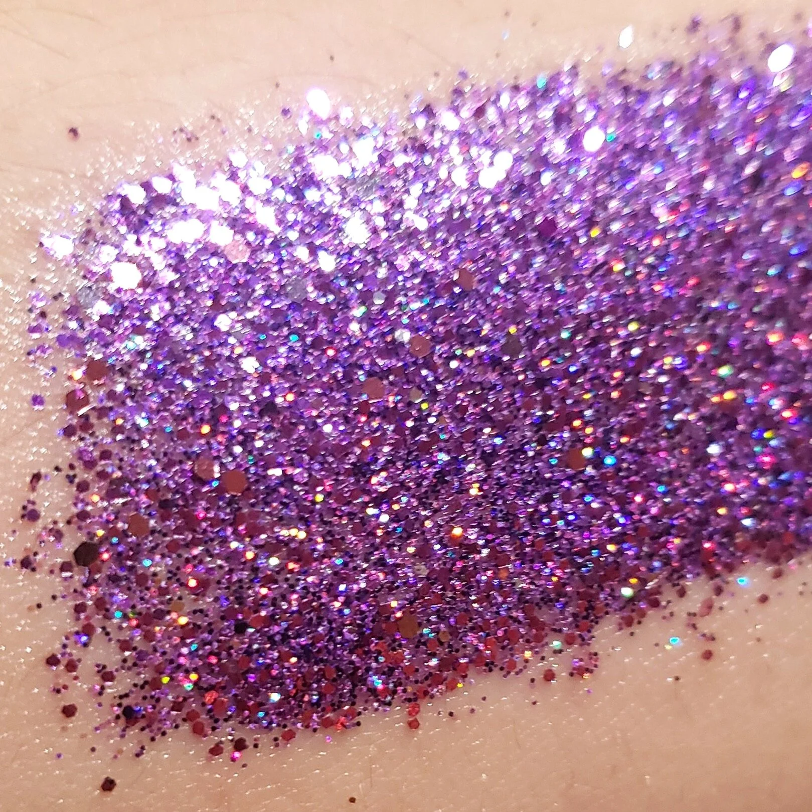 Sparkling violet purple shimmering with pink and silver  highlights of plant based glitter cream in a vegan and non toxic formula dries to a water resistant powder finish