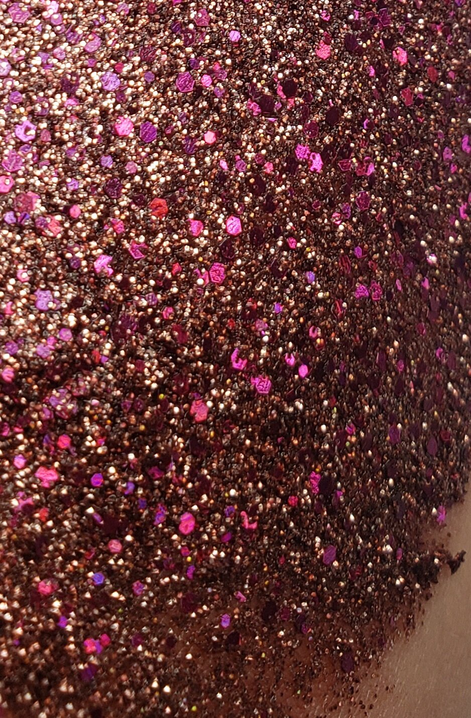 Sparkling bronze and pink with silver flecks of shimmering plant based glitter cream in a vegan and non toxic formula dries to a water resistant powder finish