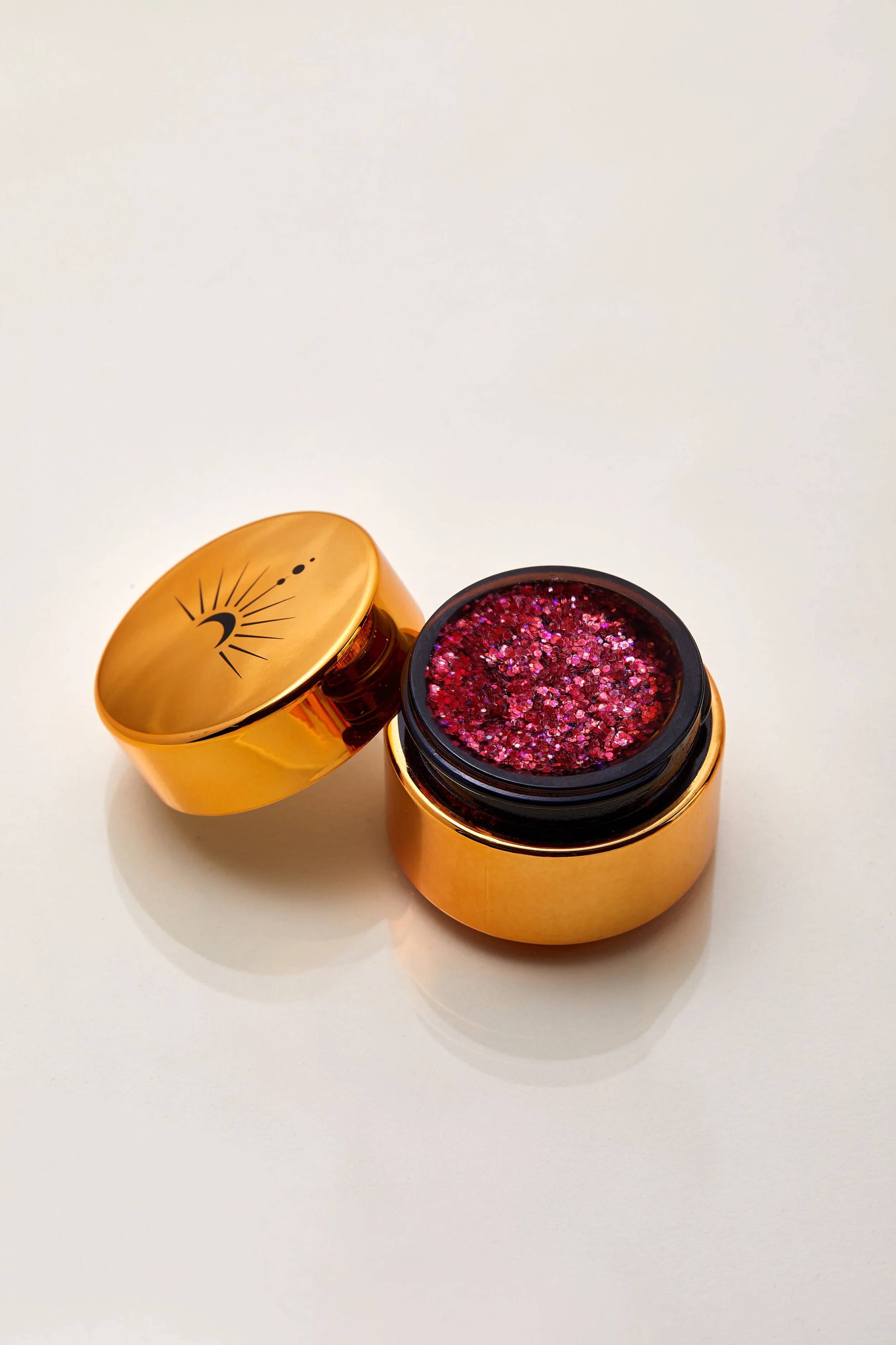 Rich ruby red shimmer with sparkling violet plant based glitter cream in a vegan and non toxic formula dries to a water resistant powder finish