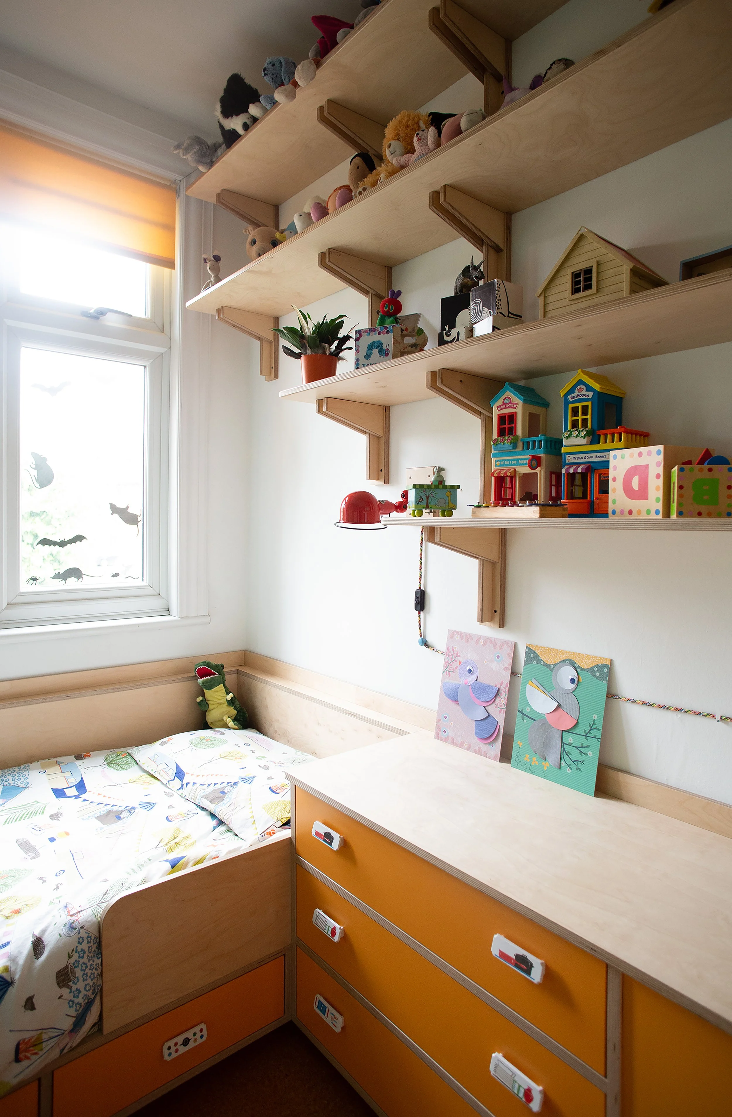 This built in bed and cabinet makes use of every available millimetre in this teeny tiny room and the shelves provide extra storage without being too heavy on the eye.