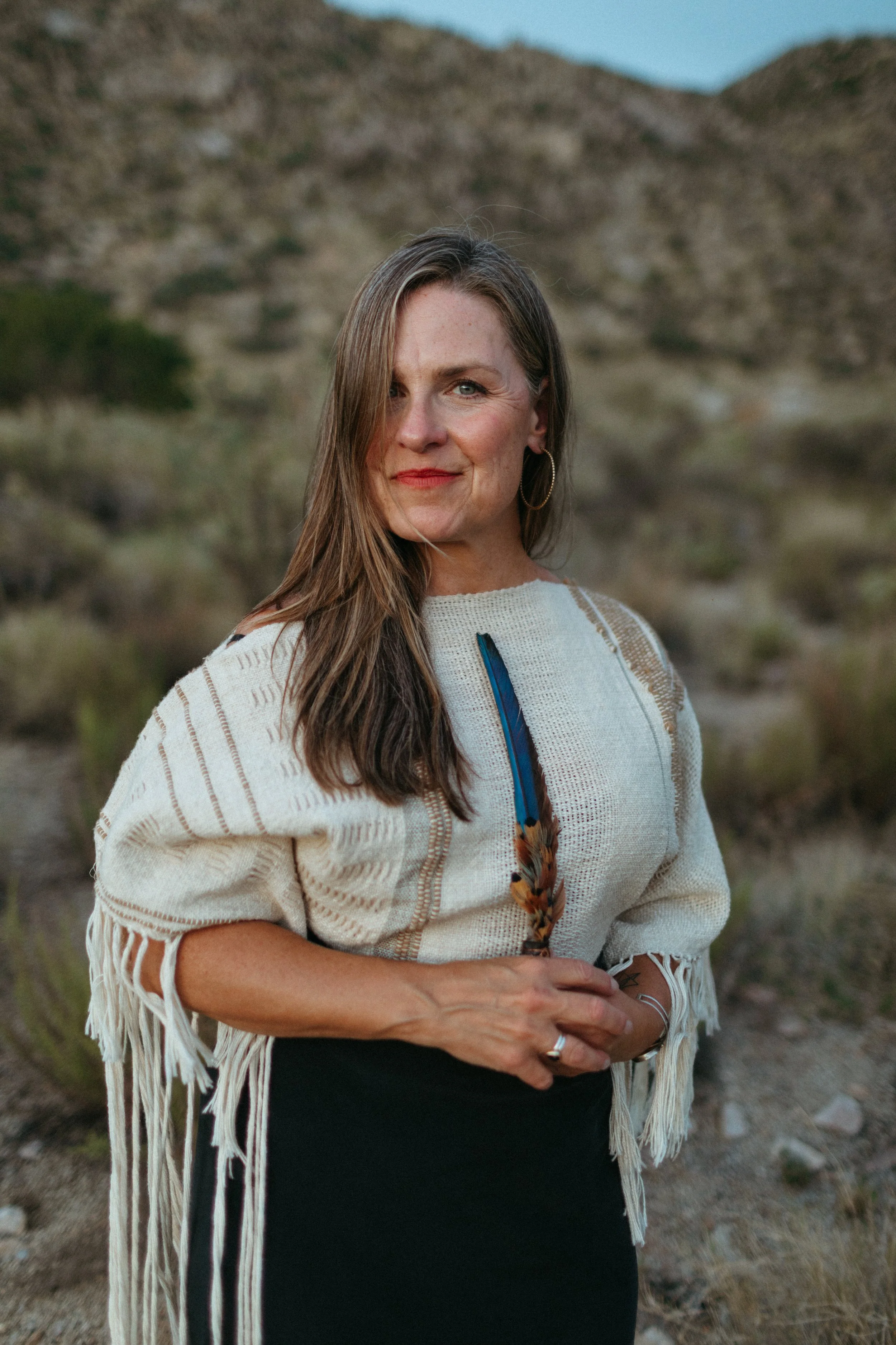 Woman in the desert with a blue Macaw Feather