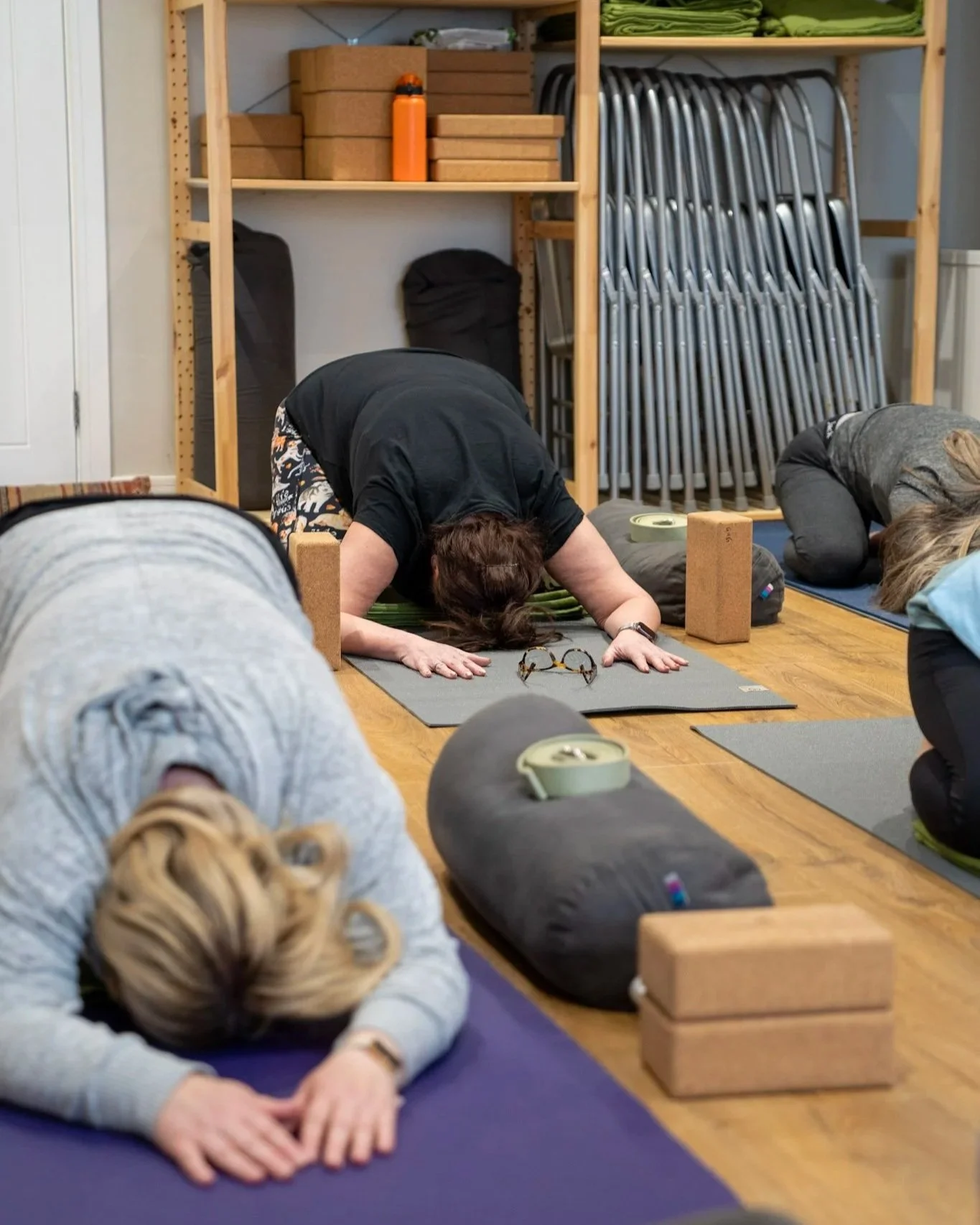 Women in a somatic yoga class in childs pose