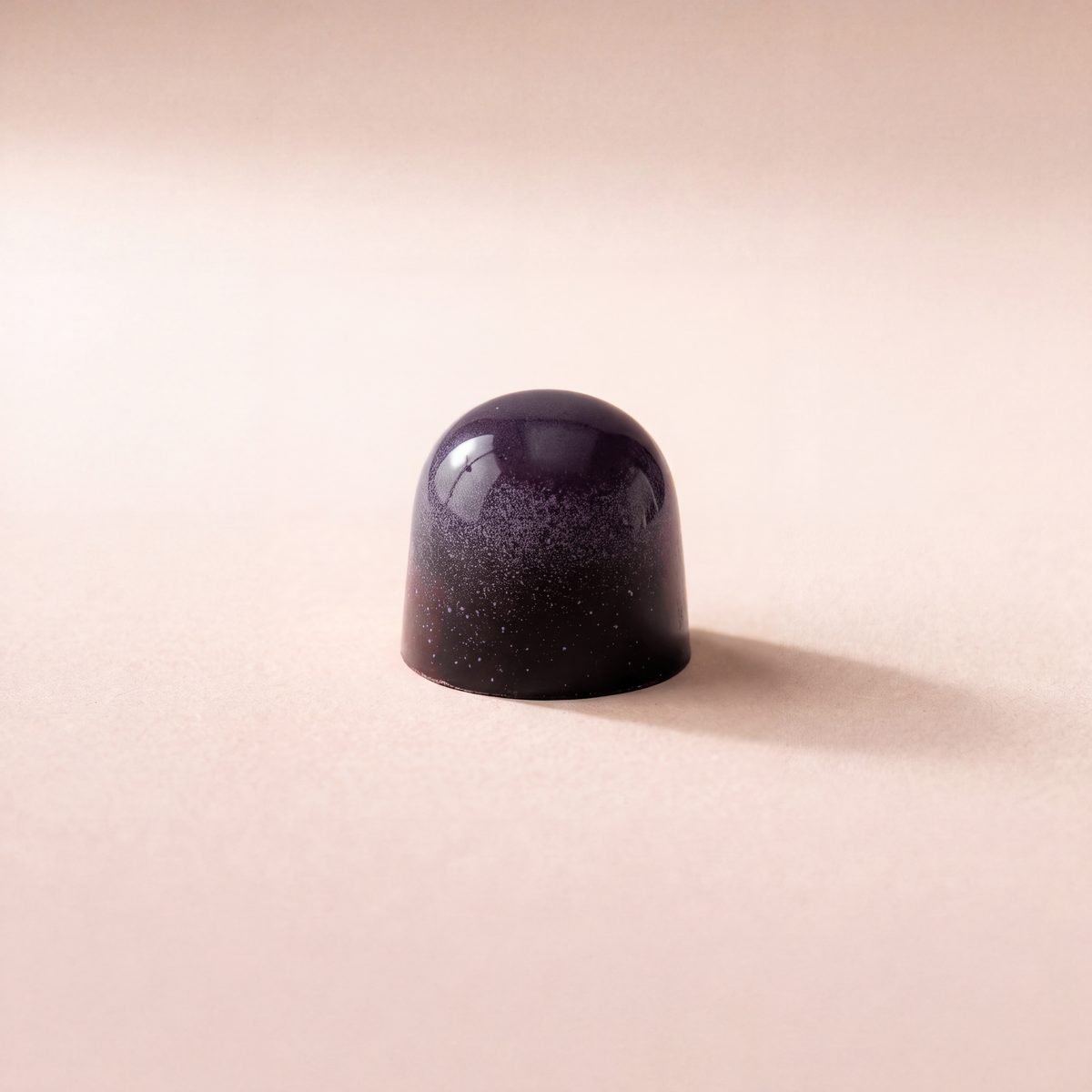 Passionfruit Soft Caramel bonbon, dark chocolate shell with a purple top