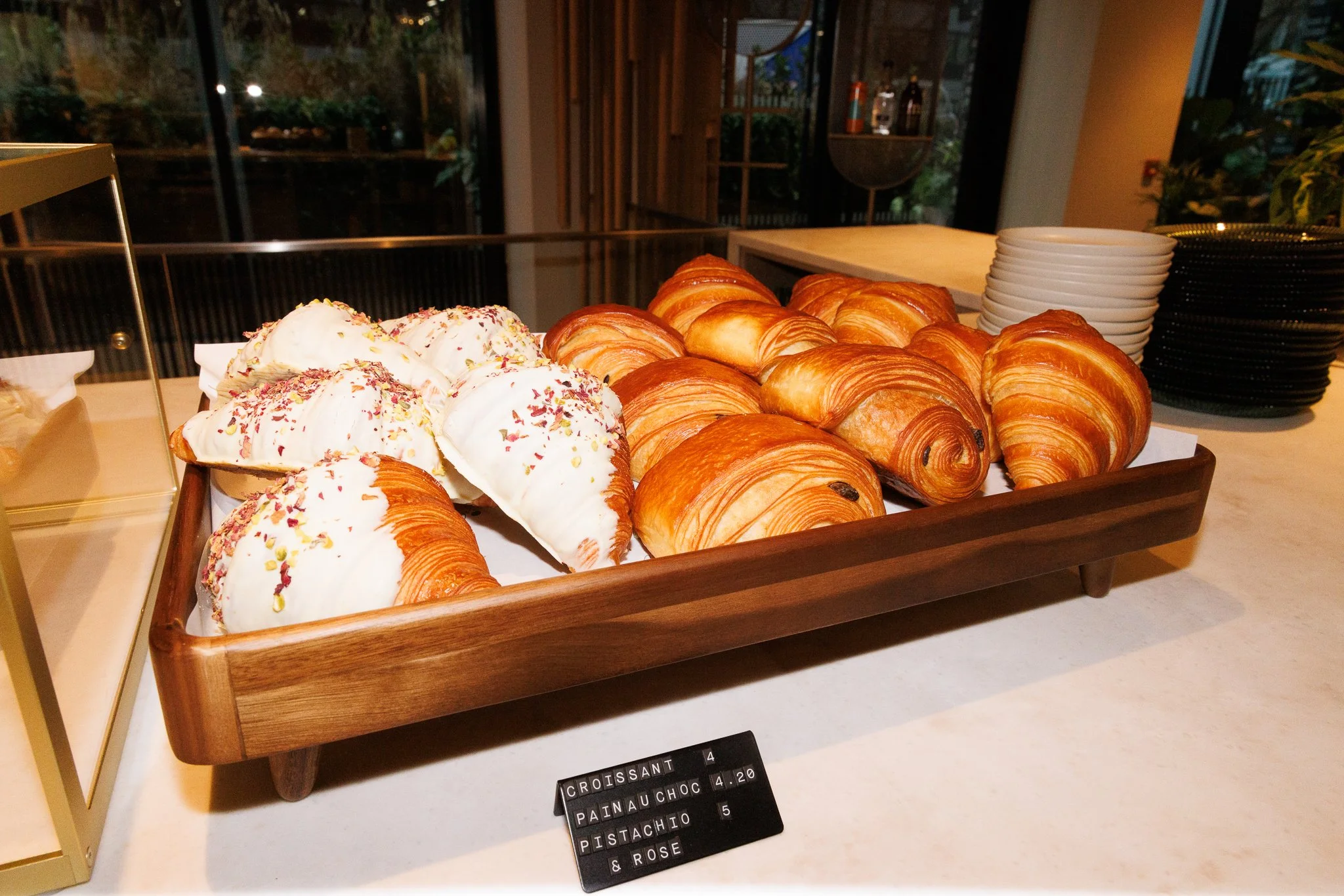 Tray of assorted pastries including croissants and pain au chocolat on a breakfast buffet table.