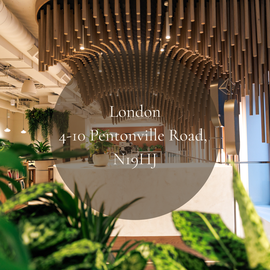 Interior of an office with a modern design, featuring wooden ceiling decorations, green plants, a white marble reception desk, and warm lighting.
