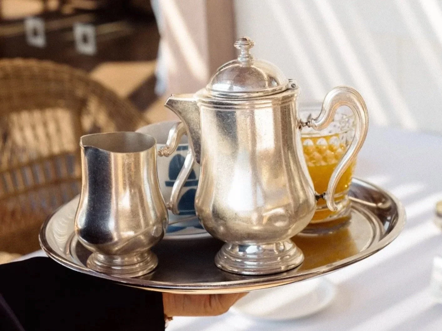 Silver tea set on a tray with a teapot, creamer, and sugar bowl at the beautiful Blue Palace Hotel in Greece. 