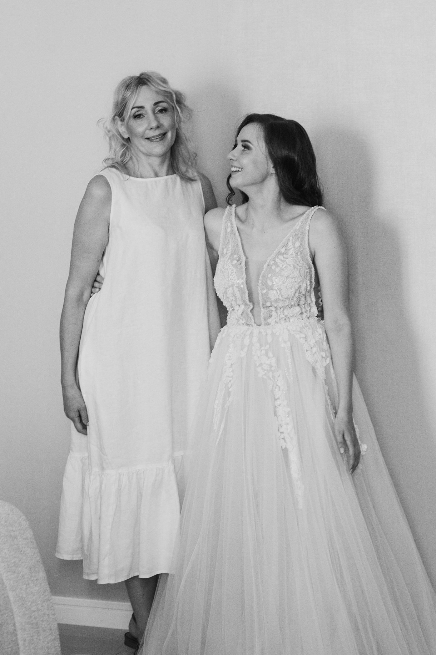 Bride and another woman in light dresses, smiling