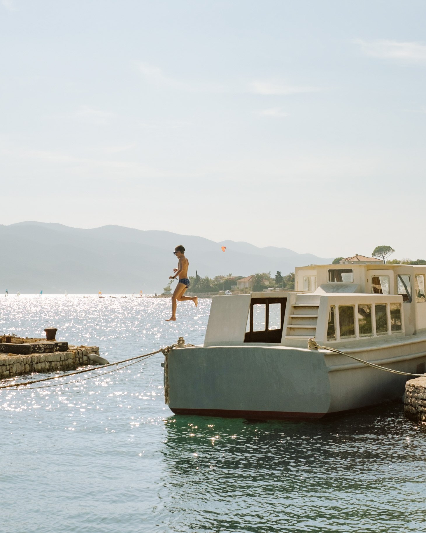 Boy jumping in the sea from a boat at Peljesac coastline