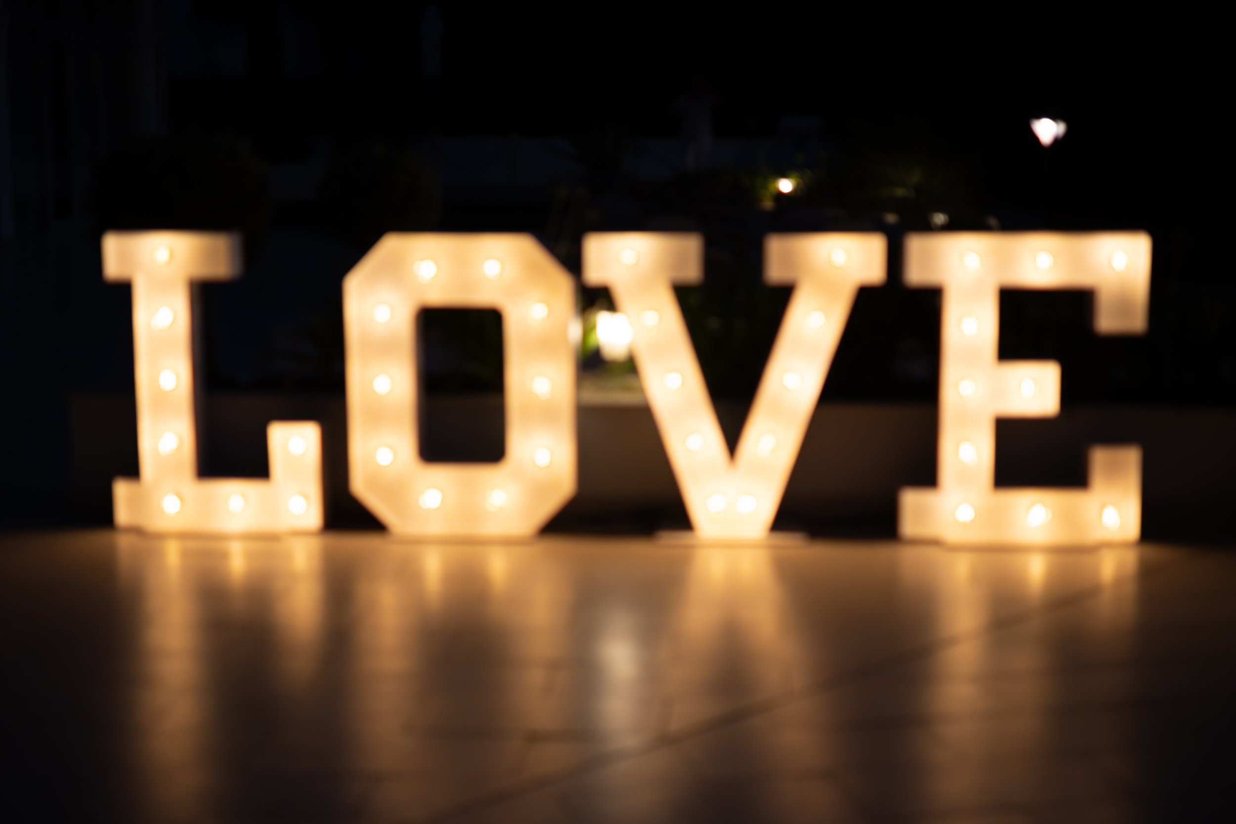 Blurry illuminated "LOVE" letters in the dark