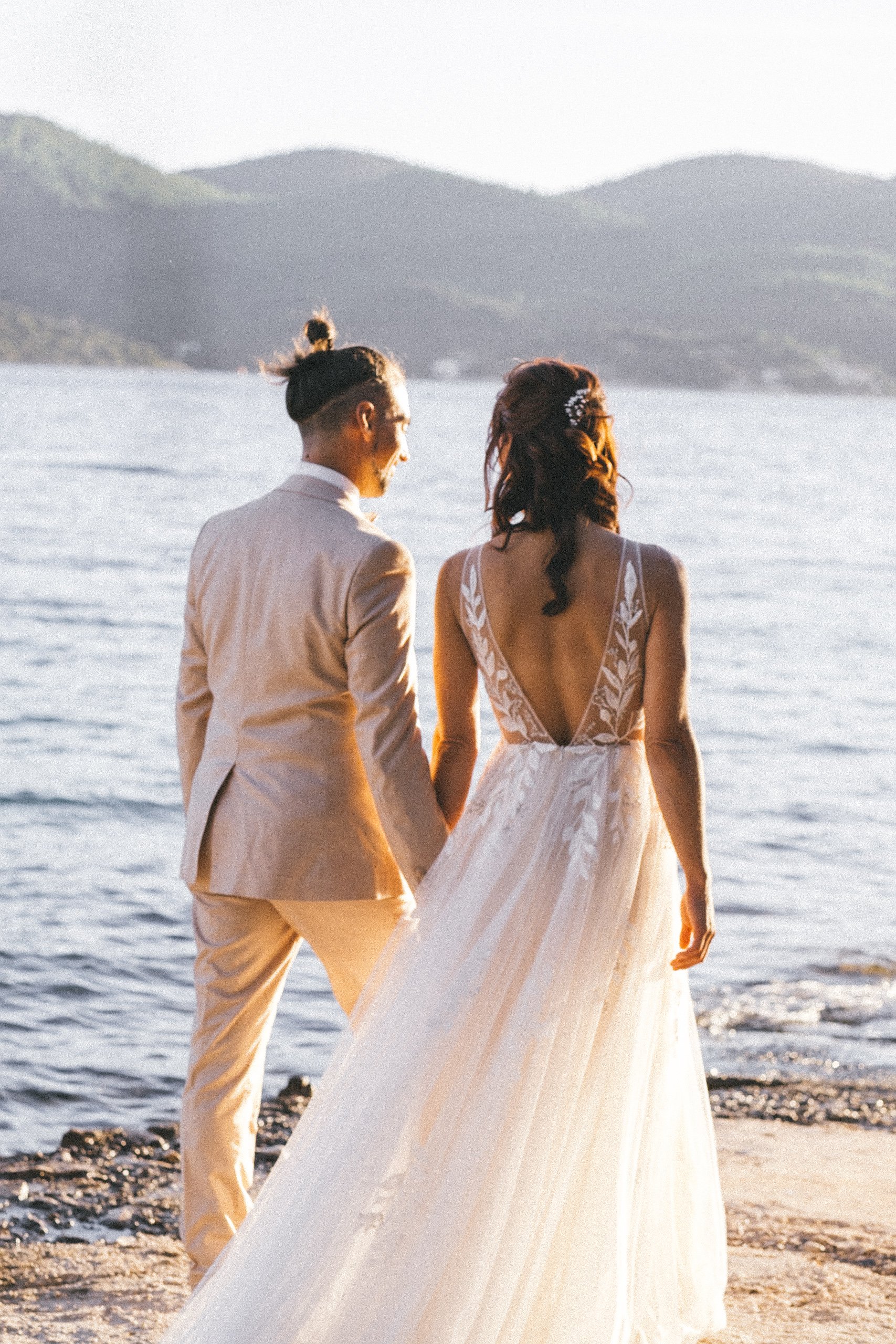 Bride and groom holding hands by the sea