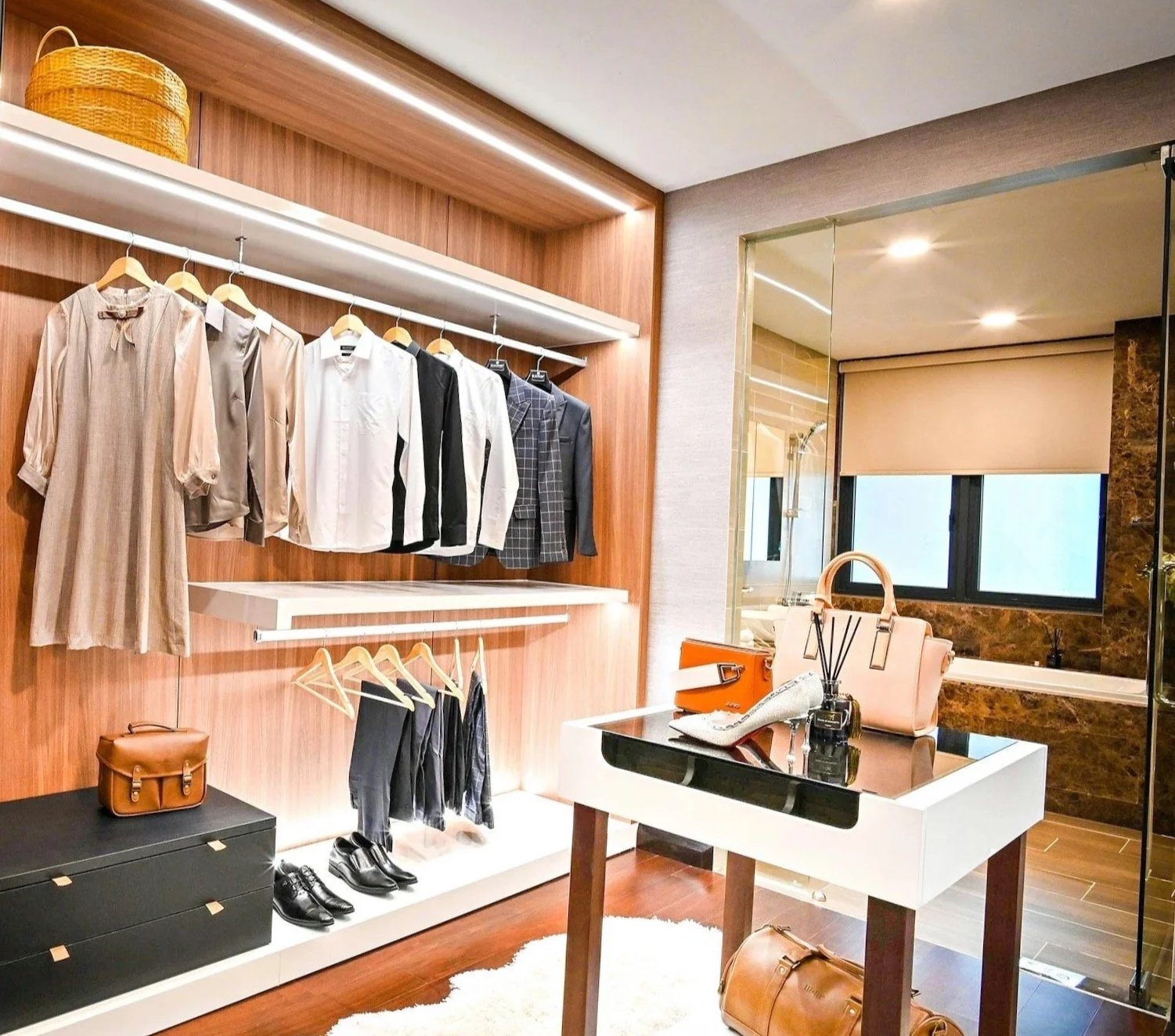 Clothing store display with hanging shirts and dresses, handbags on a table, and shoes on the floor, in a modern boutique setting.