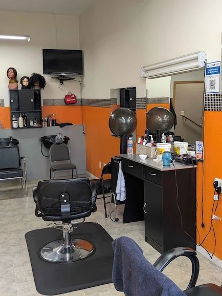 The interior of a beauty salon with chairs, service station, and equipment.