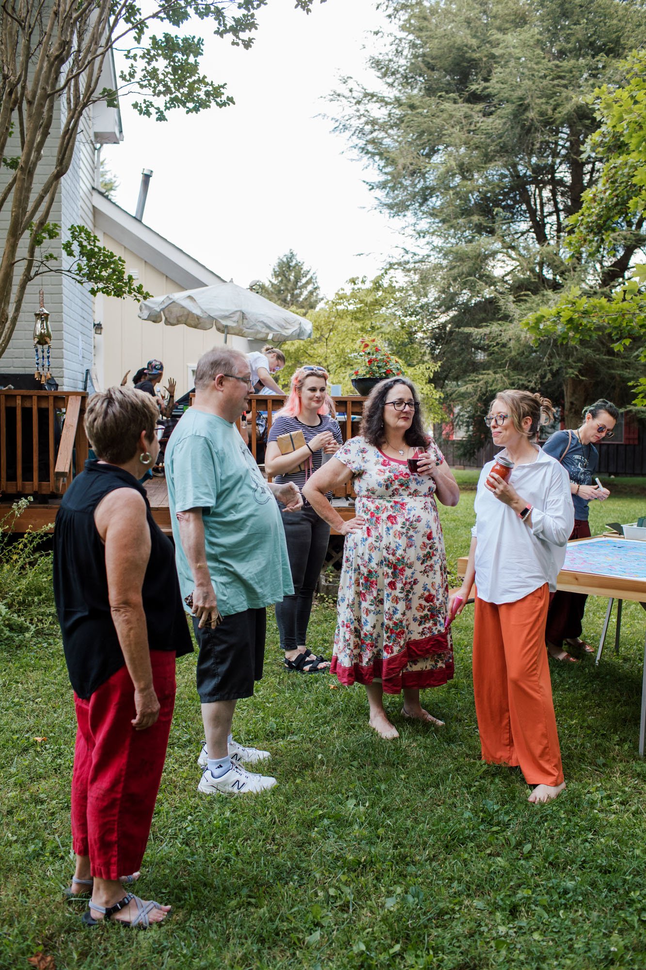 Guests speak with EAT/ART curator Jocelyn Mathewes on the lawn.