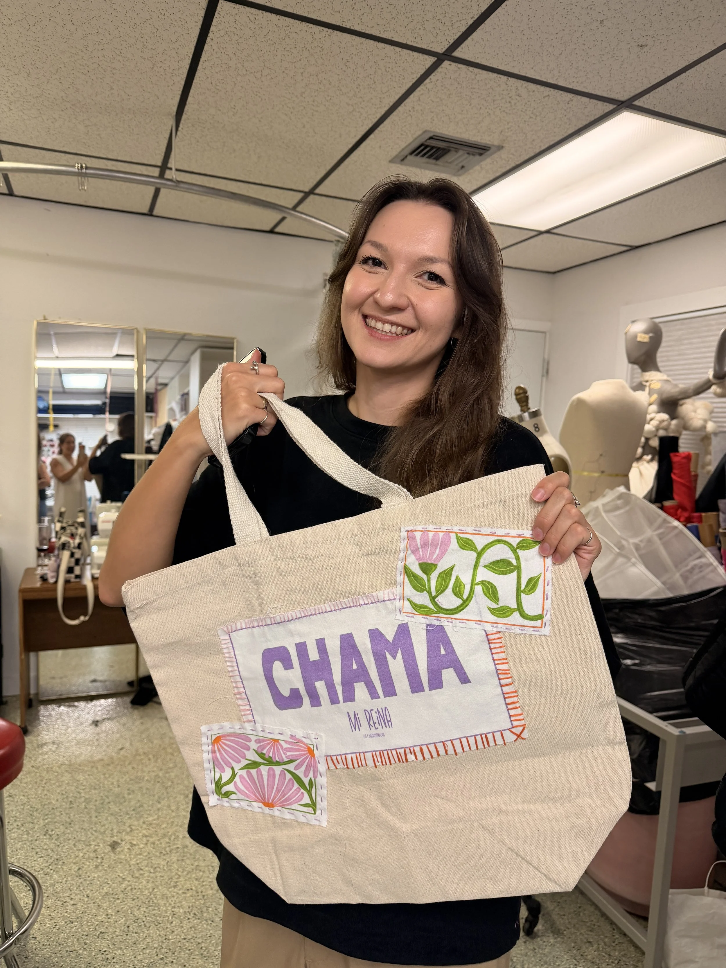 Woman with a tote bag in her hands, with an illustrated patch and embroidery around it.