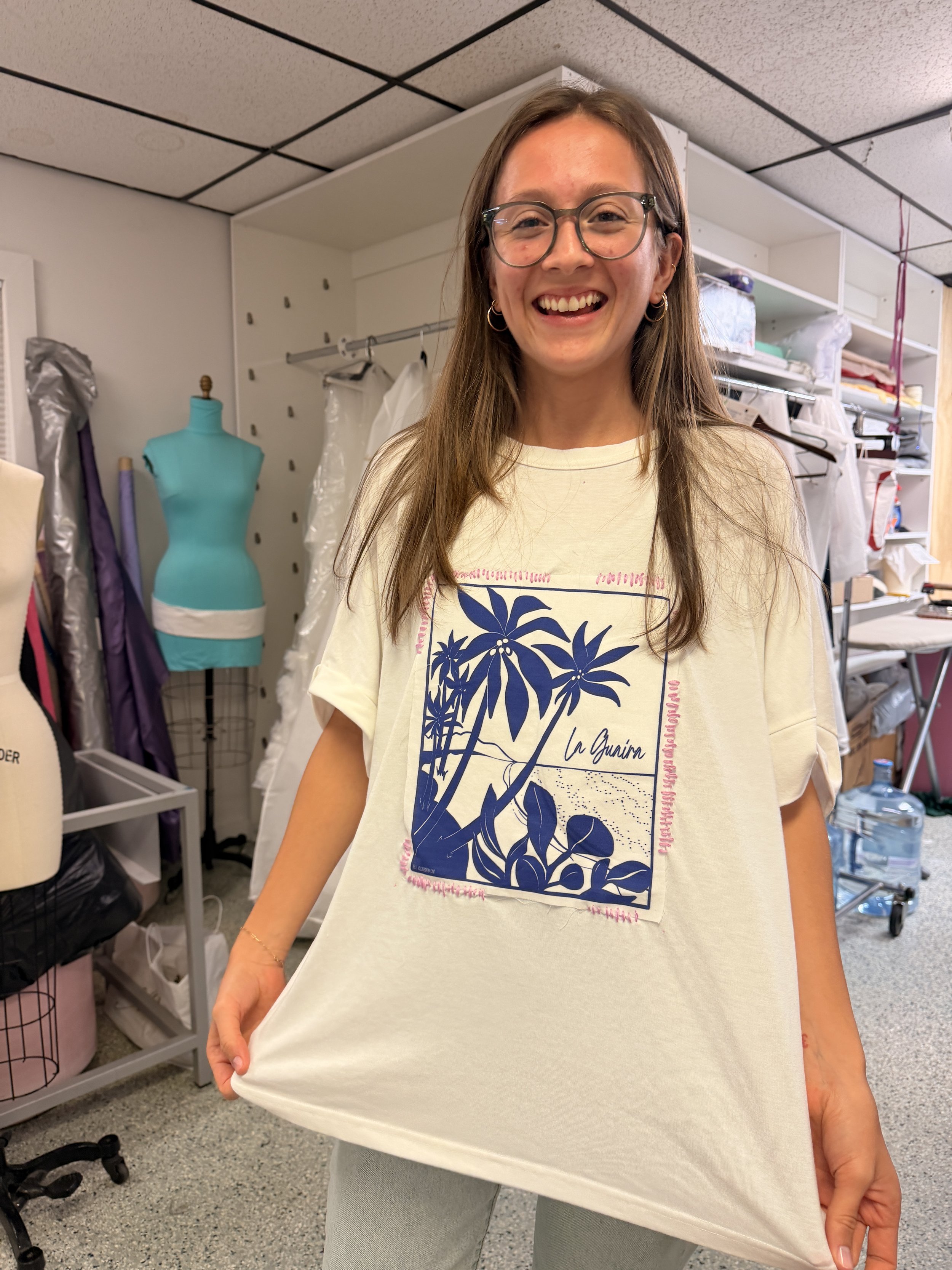 Woman with a t-shirt just embroidered by her.