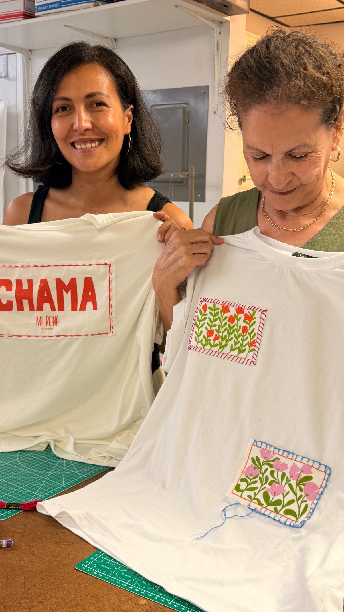 Women holding the t-shirts they just made