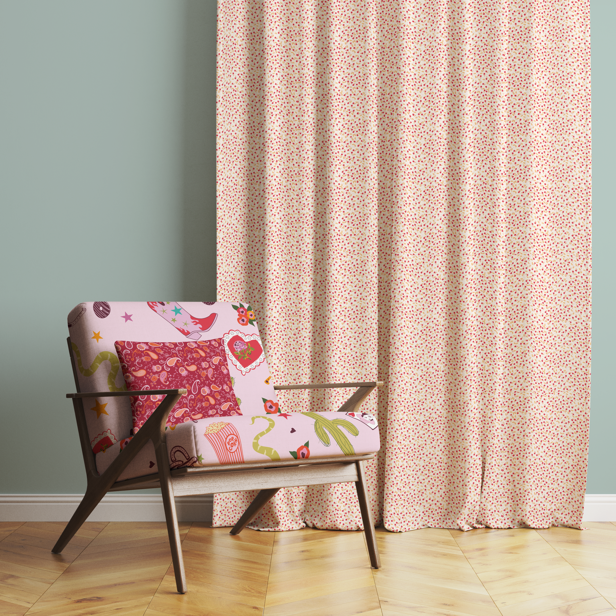 A vintage armchair with a pink流w fabric featuring a playful pattern of watermelon slices, flowers, stars, and hair dryers, positioned on a hardwood floor against a light blue-green wall. Behind the chair, there is a floor-length curtain with a small,