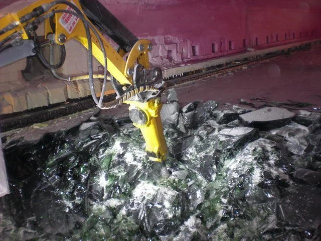 Brokk med hammer meisler glass i ovn