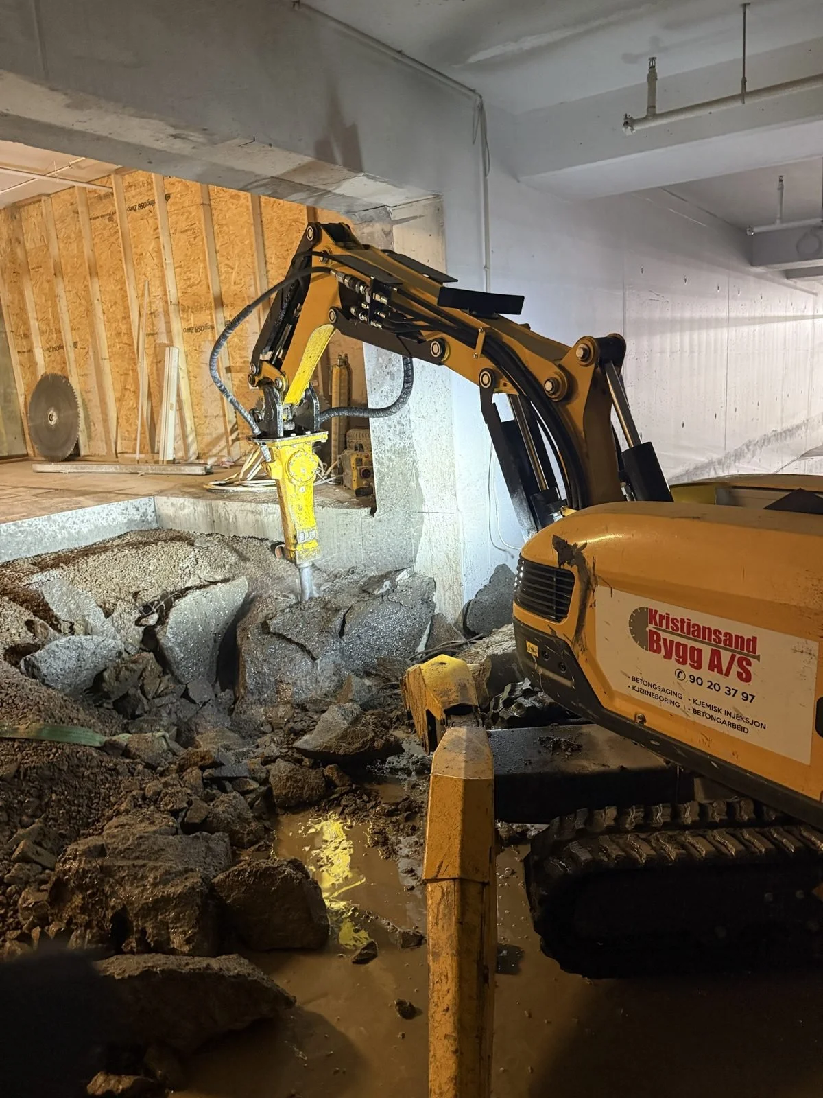 Brokk rivemaskin med hydraulisk hammer meisler betong og fjell i kjeller