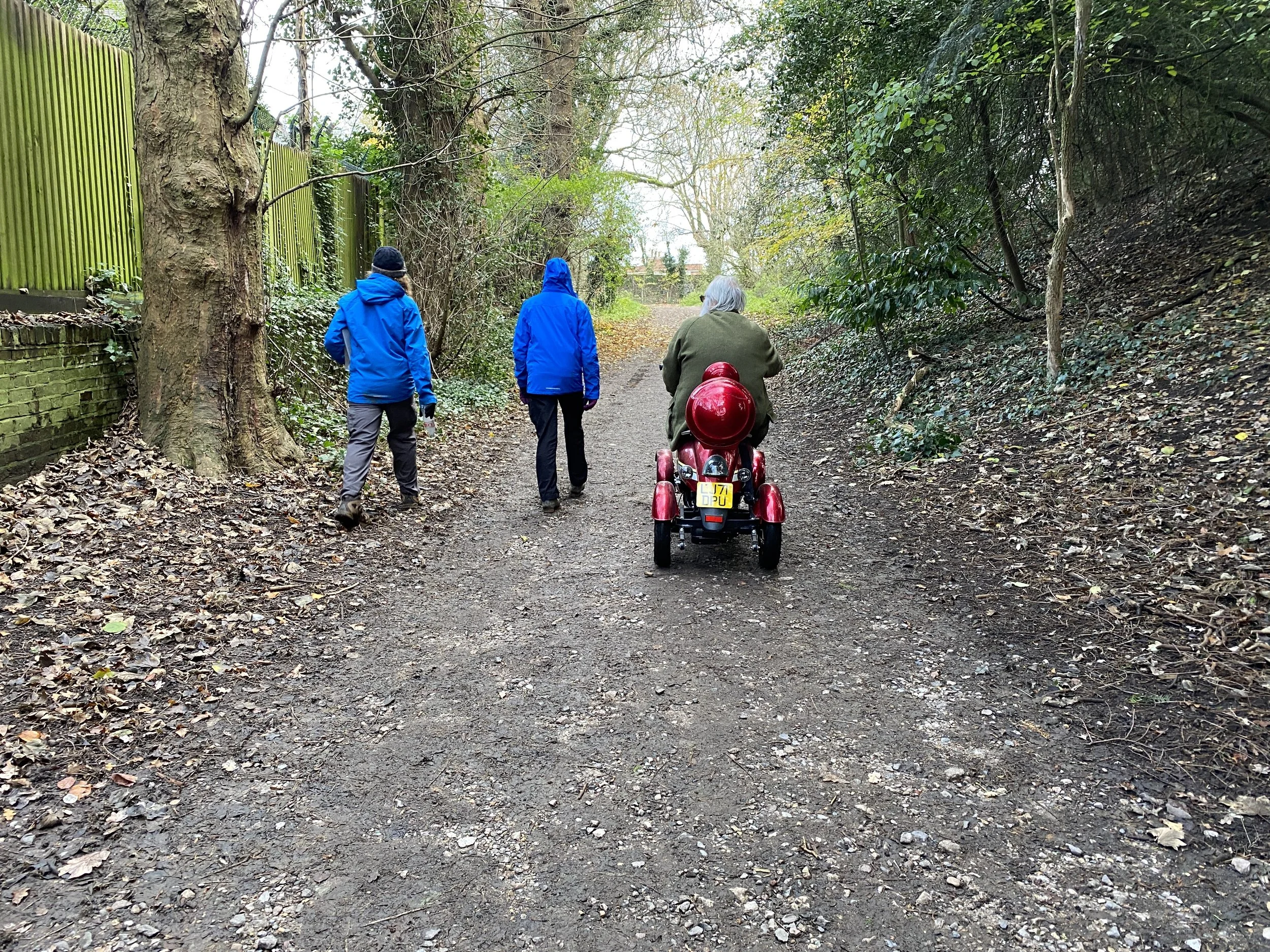 Two people walking and one in a mobility scooter on Hampstead Heath
