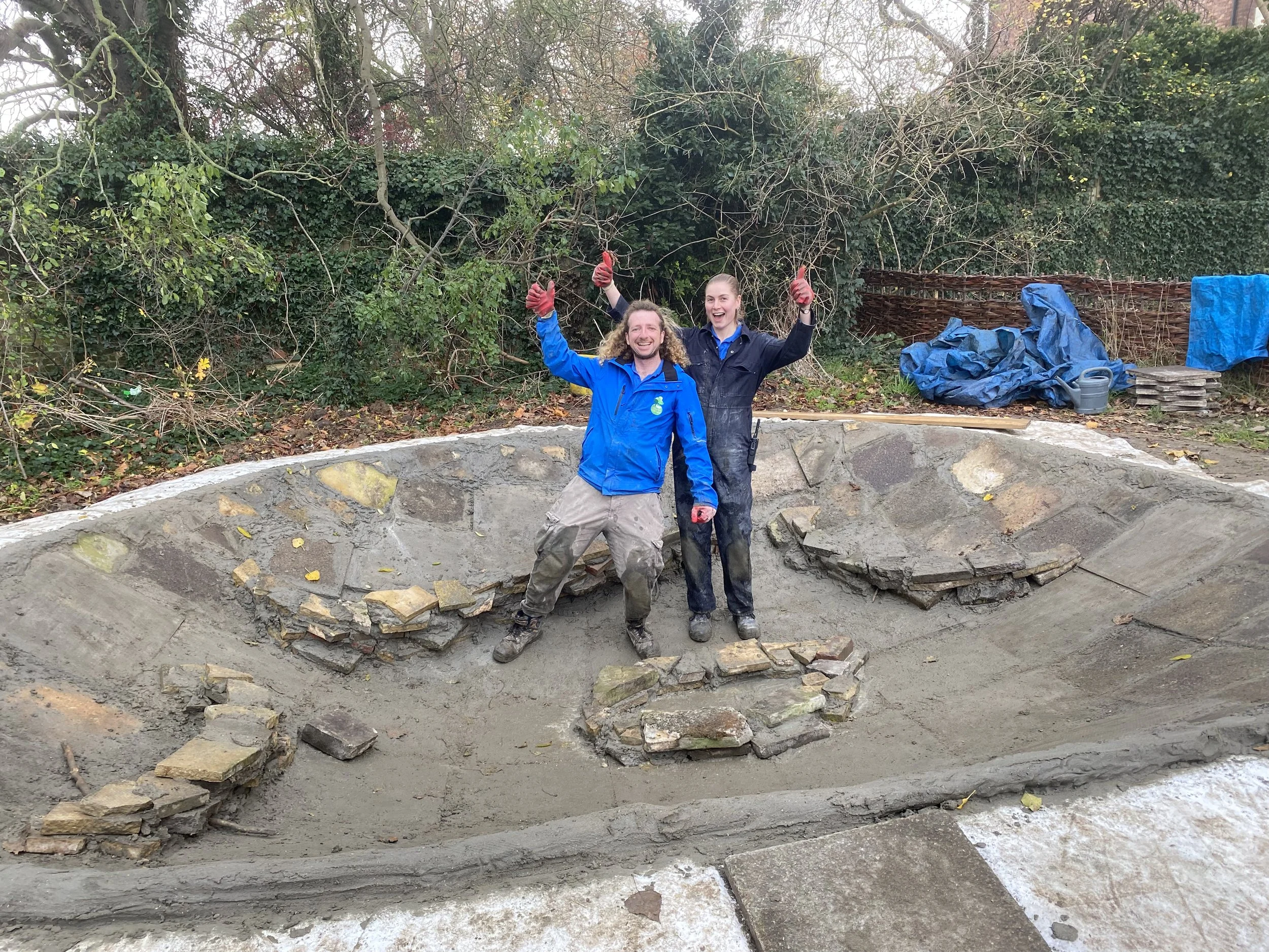 Two staff members in empty pond