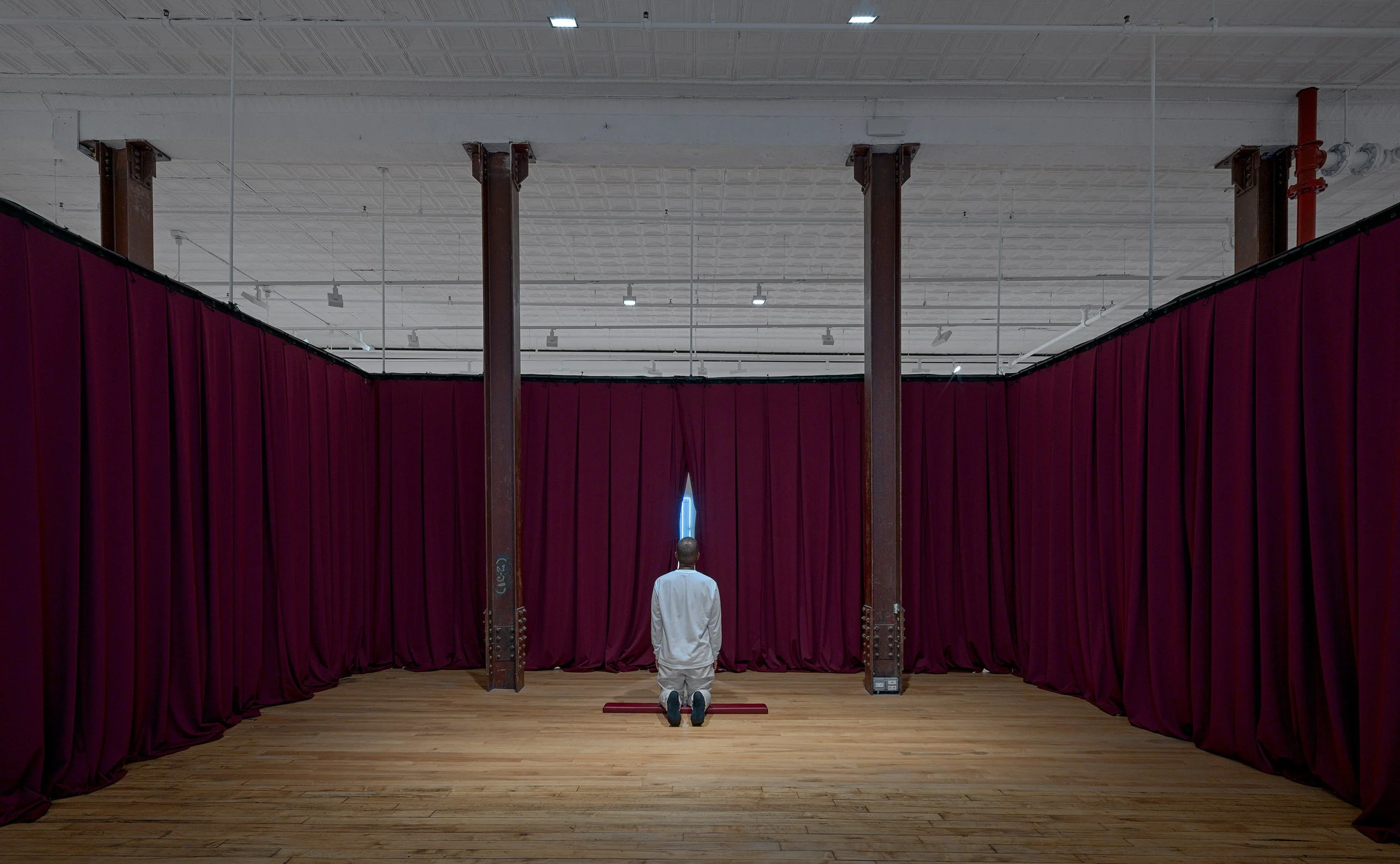 Yearning for an Absolute, 2025.
Pew kneeler pad, velvet curtains, and durational performance.
Photo: Kerry McFate.