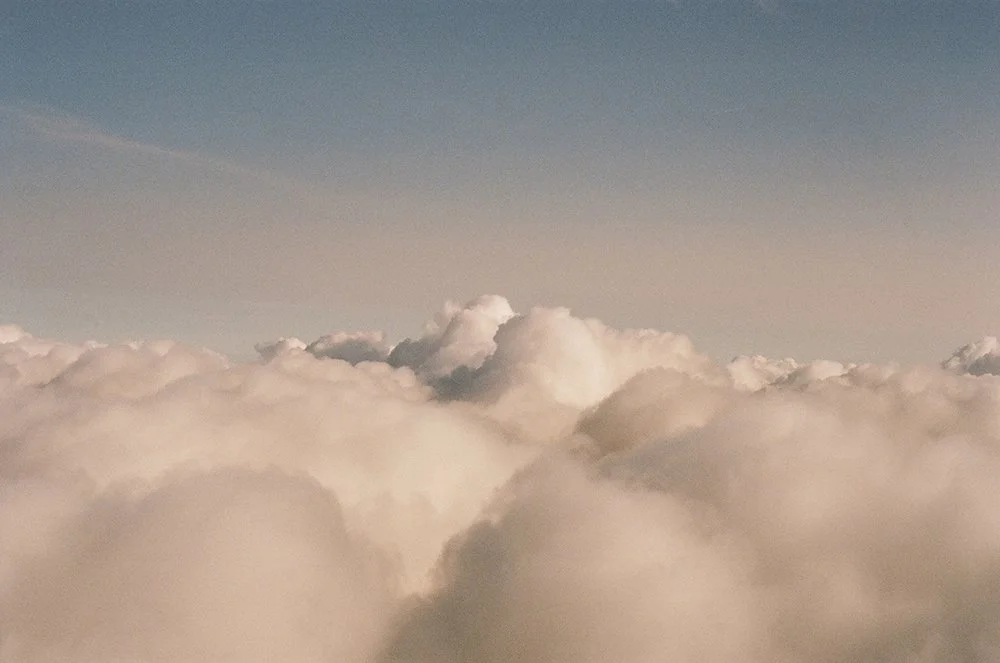 A view of fluffy white clouds in the sky during daytime.