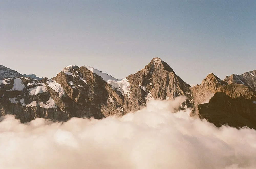 Snow-capped mountain peaks above a sea of clouds