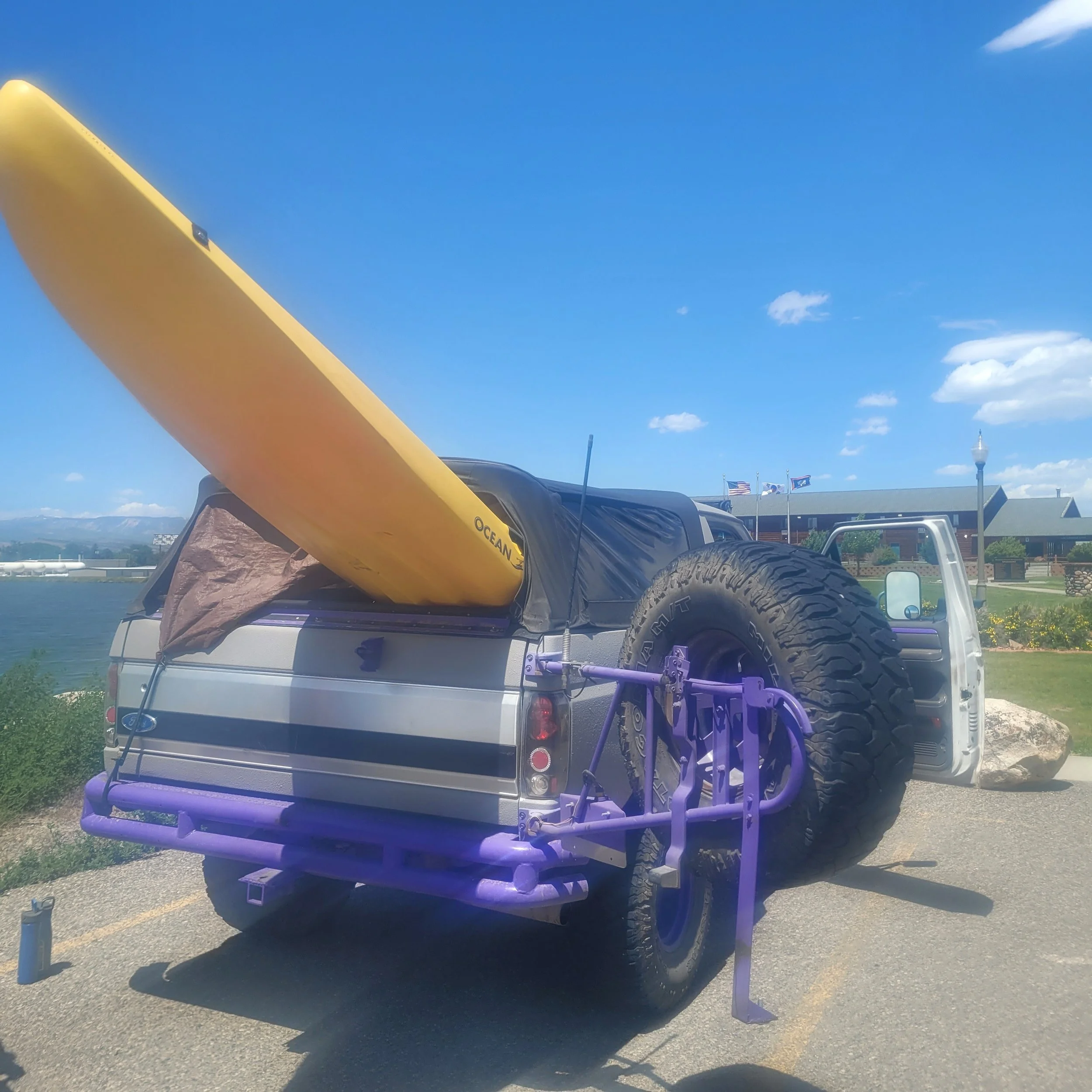 Hard kayak board in back of a classic Ford Bronco