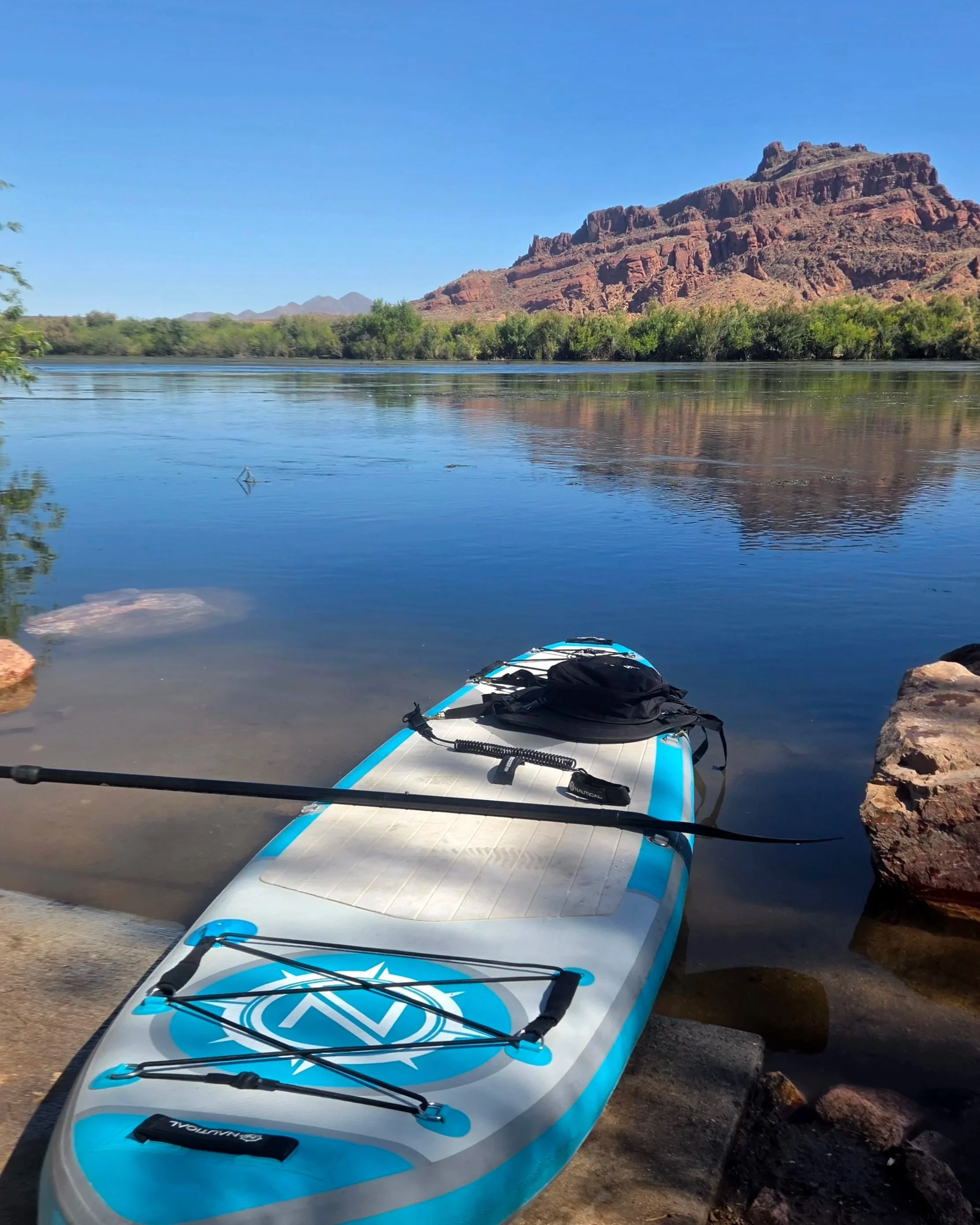 Paddleboard on river with mountains overshadowing