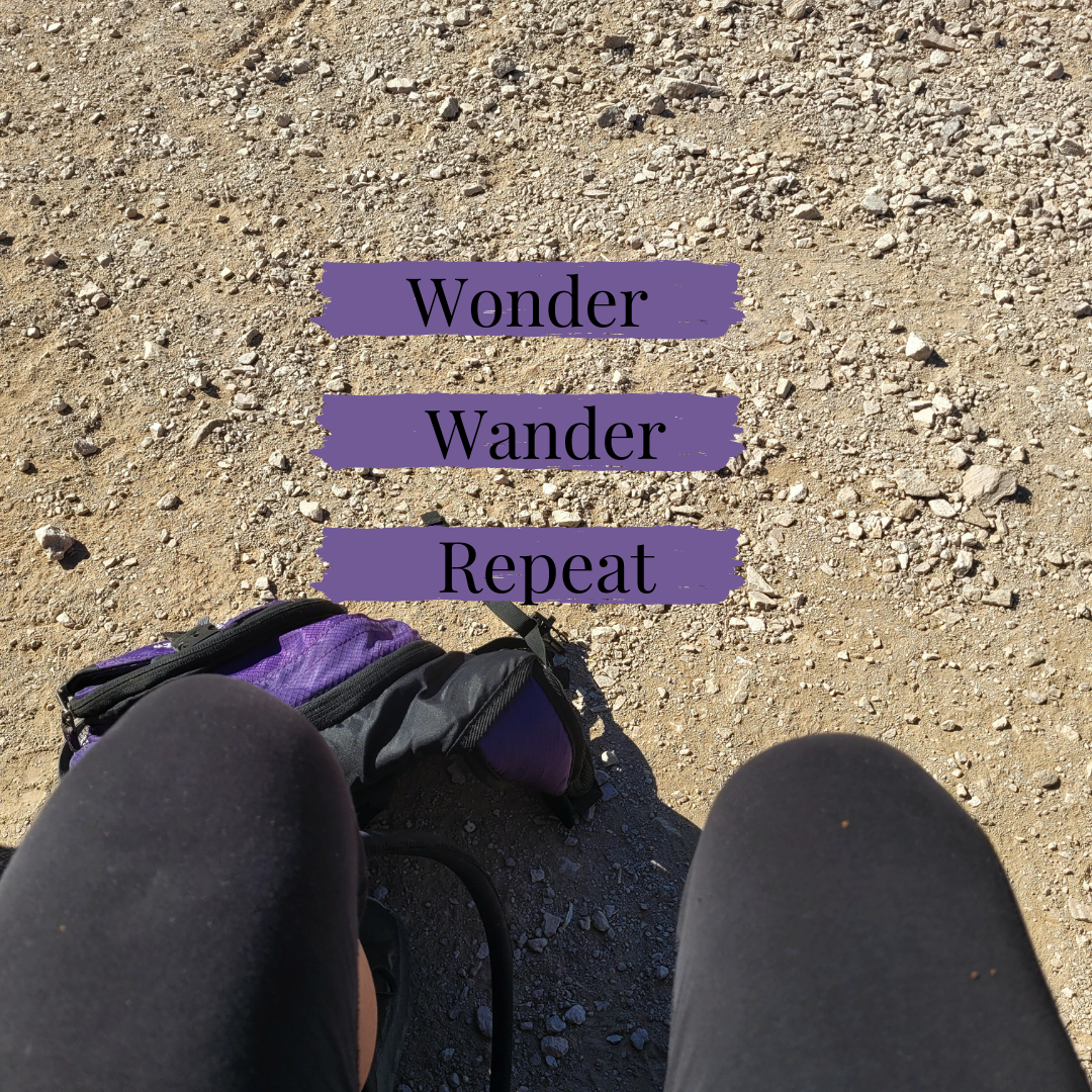 View of a dirt path with a backpack and legs in black leggings. The text "Wonder Wander Repeat" is overlaid on the image.