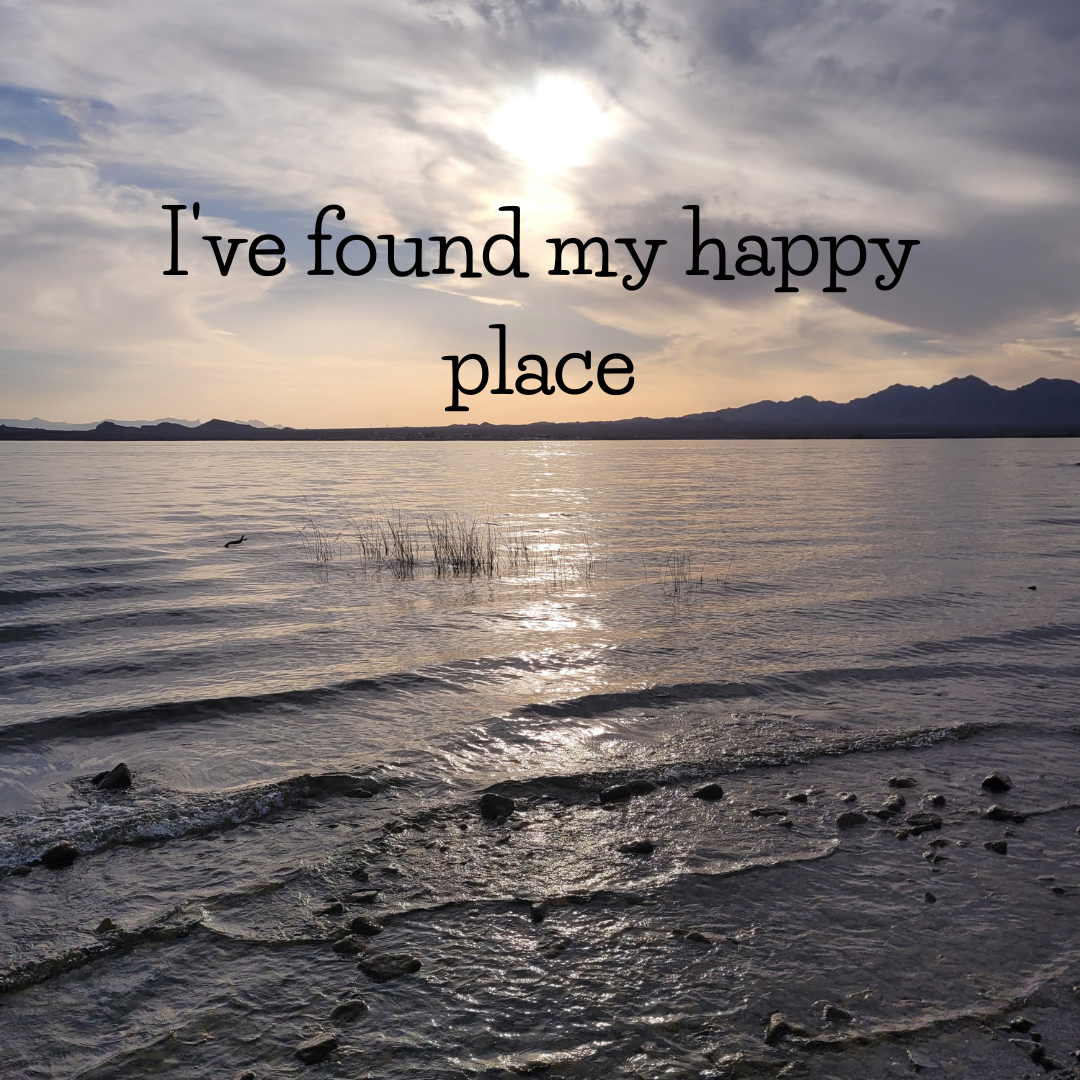 Scenic lake view at sunset with mountains in the background and text overlay saying 'I've found my happy place'.
