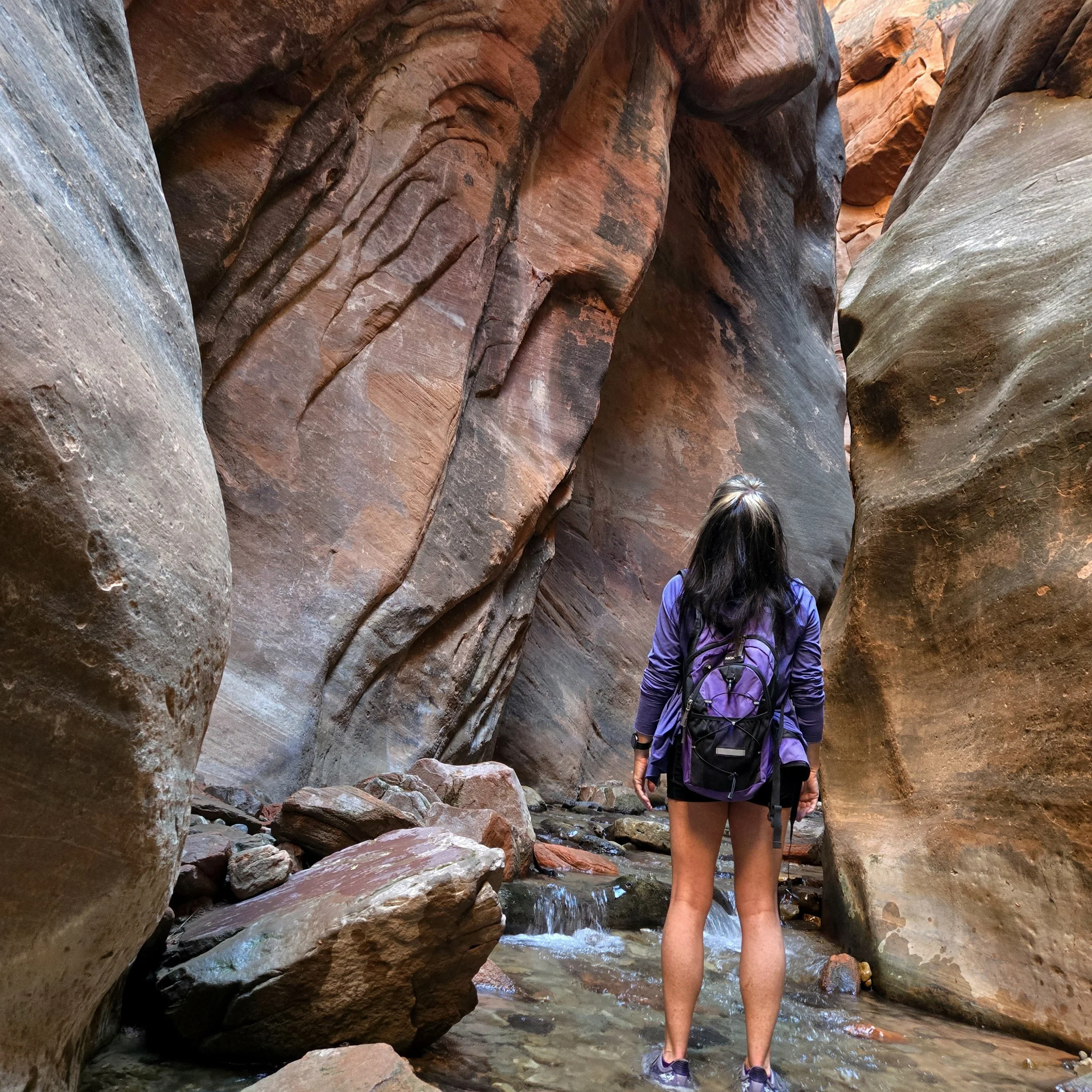 Author looking up at Kanarra Falls slot canyon walls.