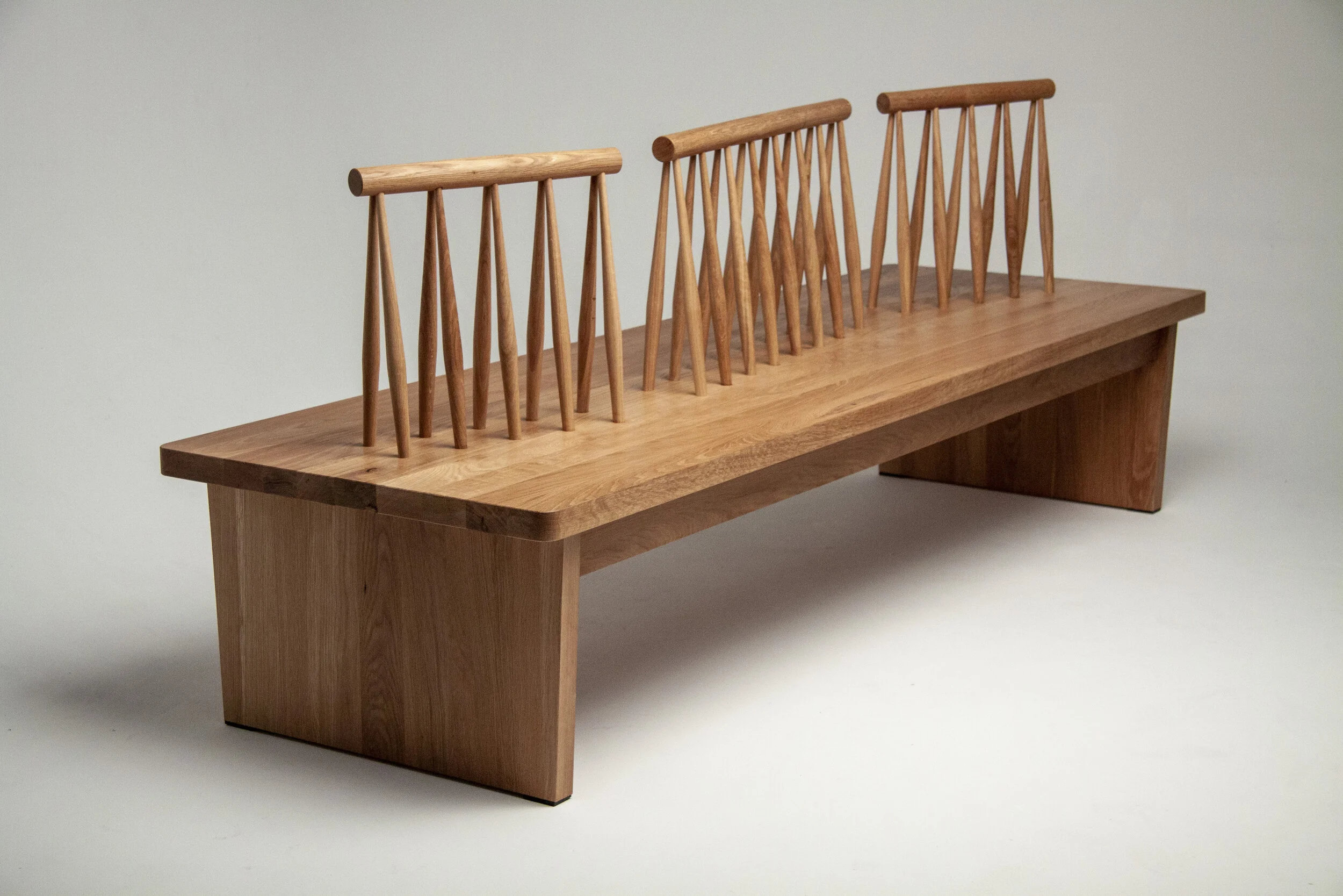 Custom furniture bench project for the North York Women's Shelter out of white oak. A communal reception entry bench that is eight feet long with zig-zagging backrests.